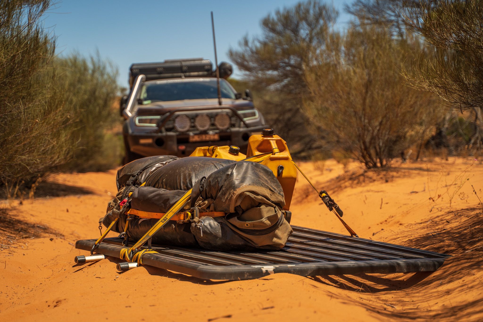 Touring gear on a platform in the Outback of Australia with a 4X4 ute in the background