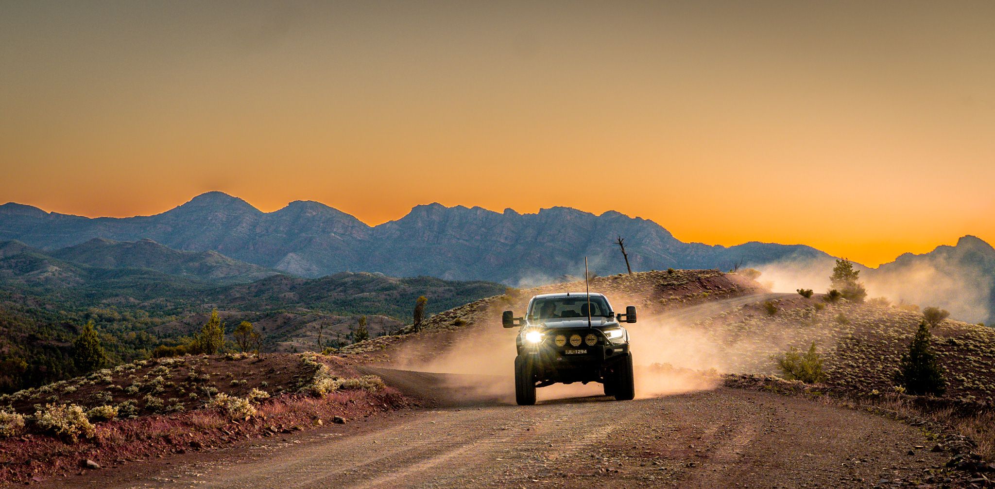 4X4 driving on dirt road at sunset
