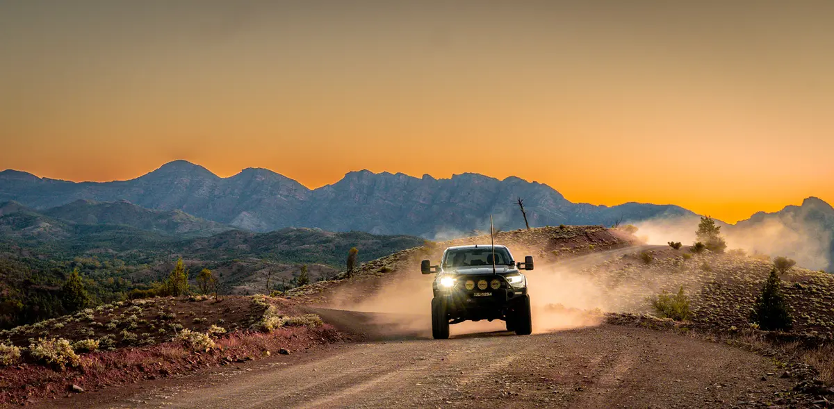 4X4 driving on dirt road at sunset