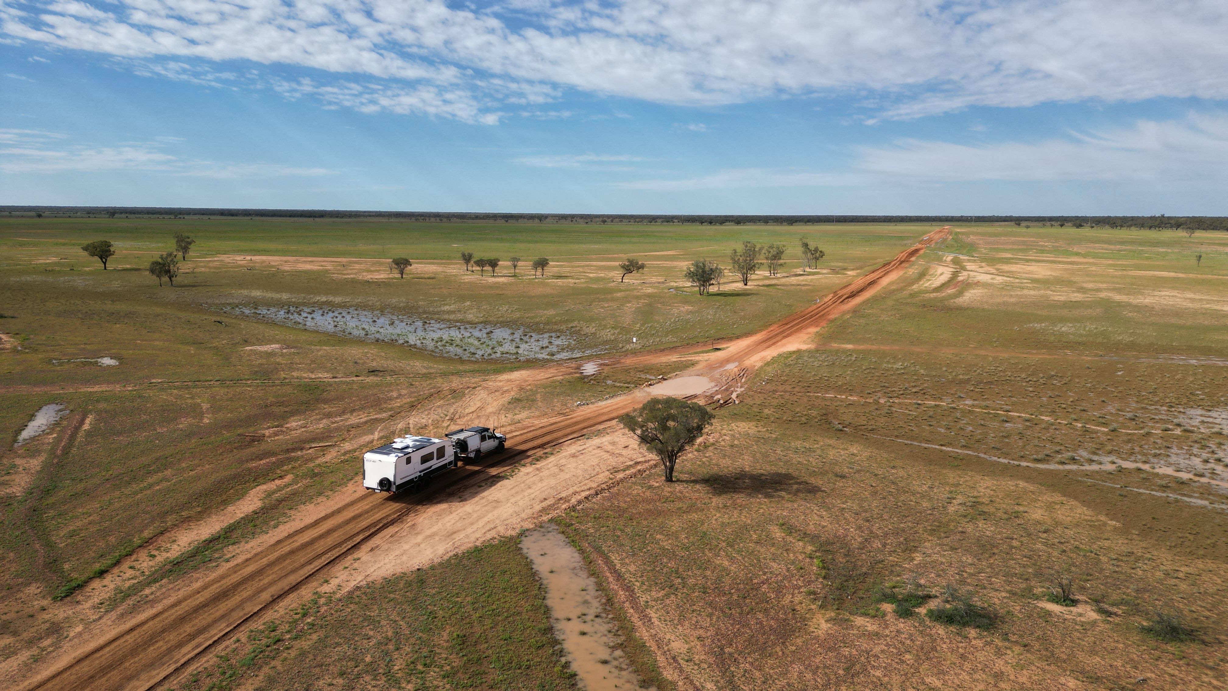 Toyota Landcruiser towing a caravan through Quilpie after a flood