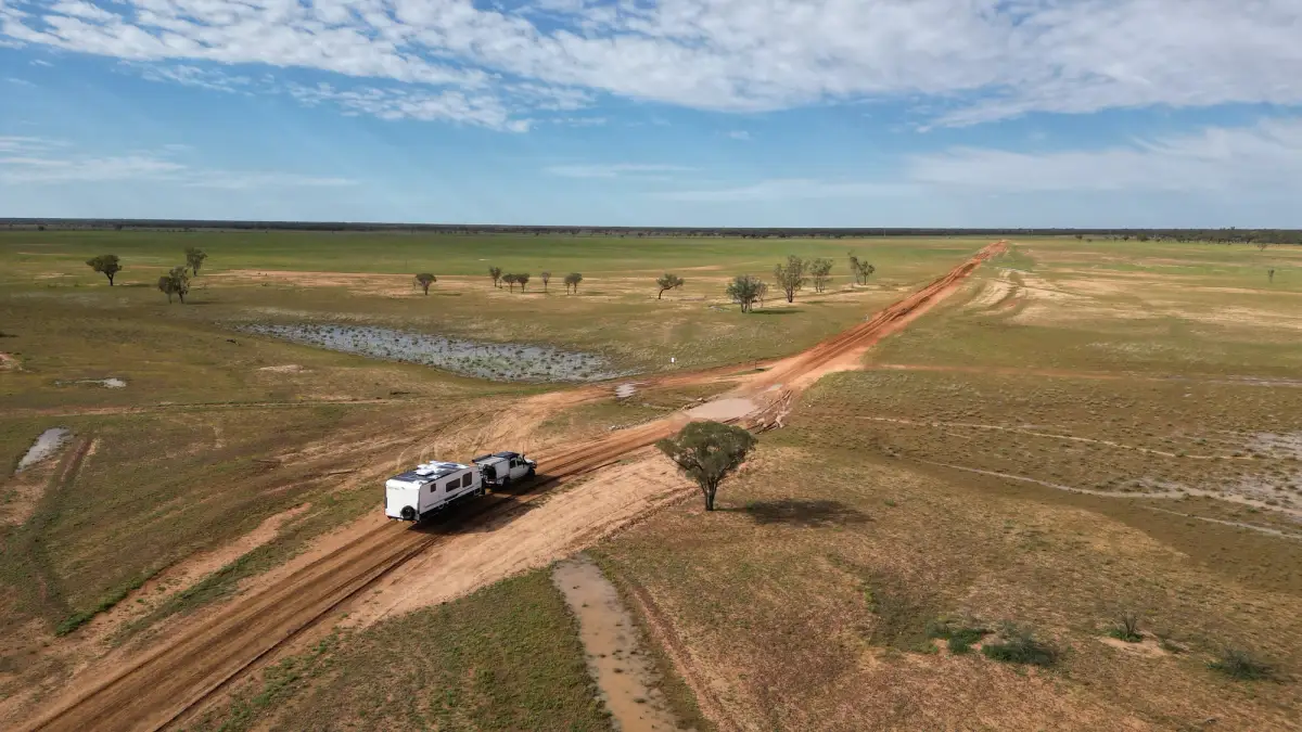 Toyota Landcruiser towing a caravan through Quilpie after a flood