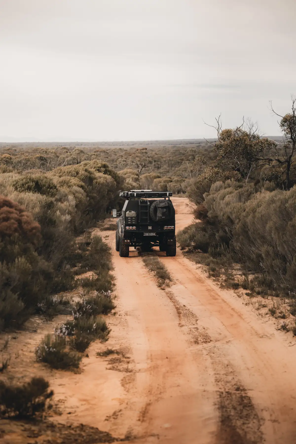 A 4X4 Ford Ranger driving down a sandy track surrounded by bush