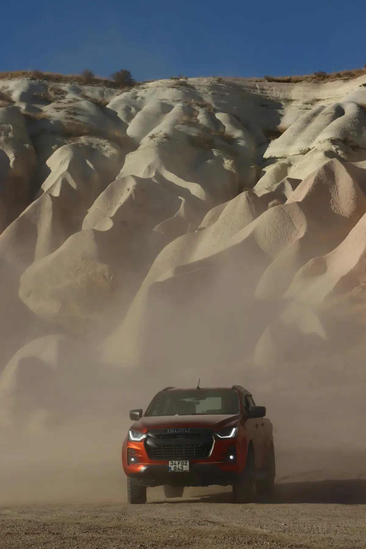 Isuzu d-max in front of a sand dune orange 4x4