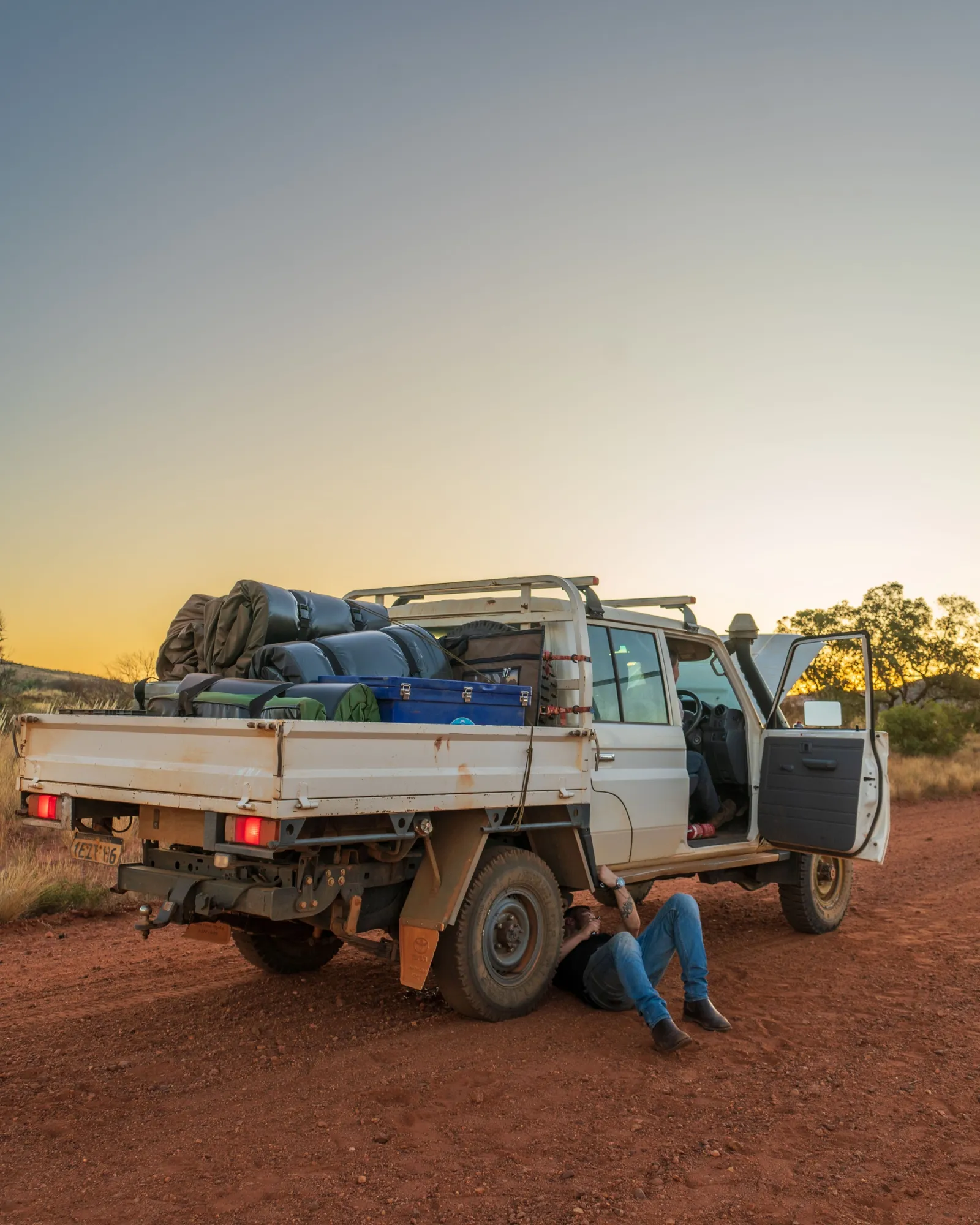 loaded ute with person underneath fixing something