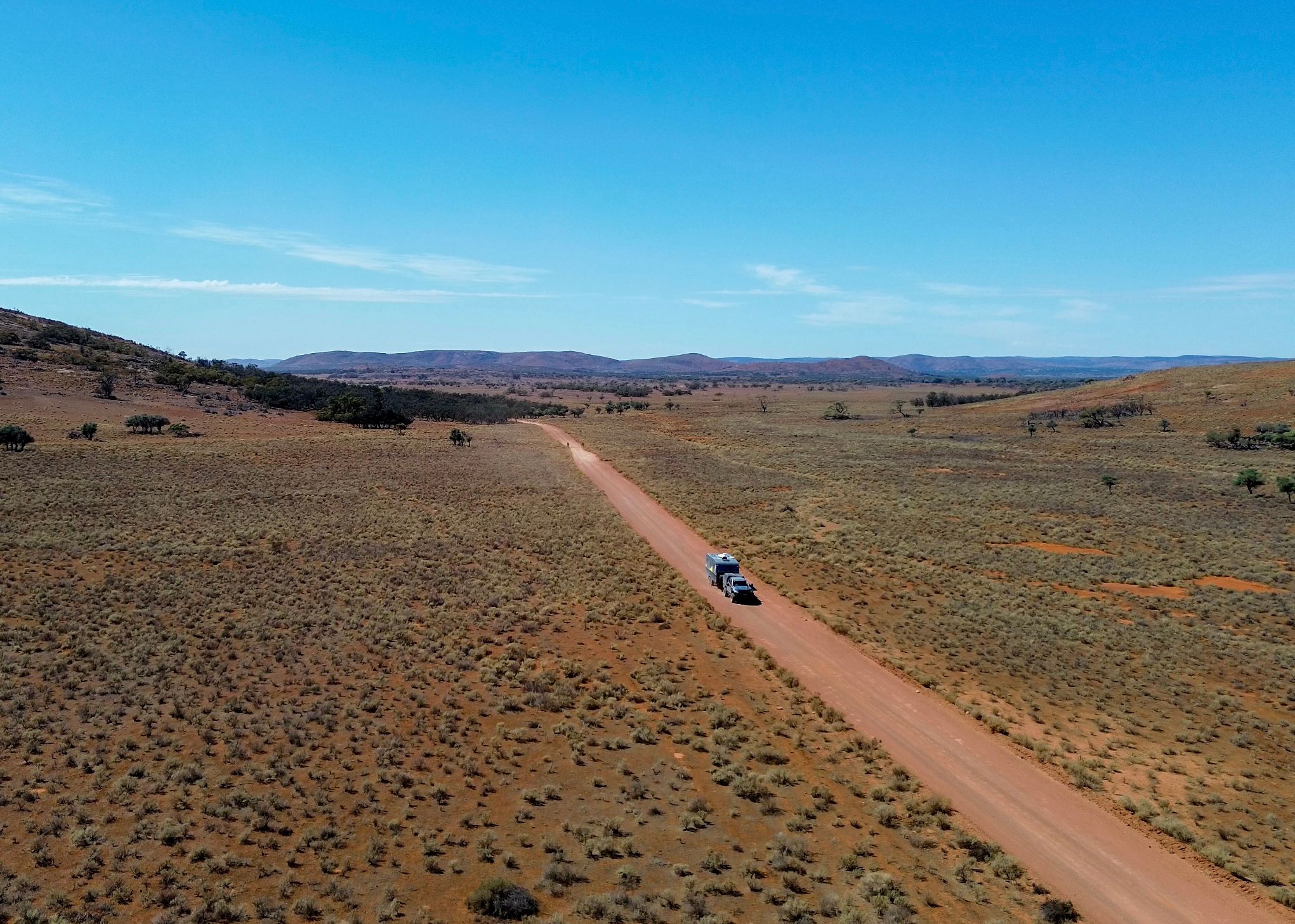 4x4 towing a caravan through an arid landscape