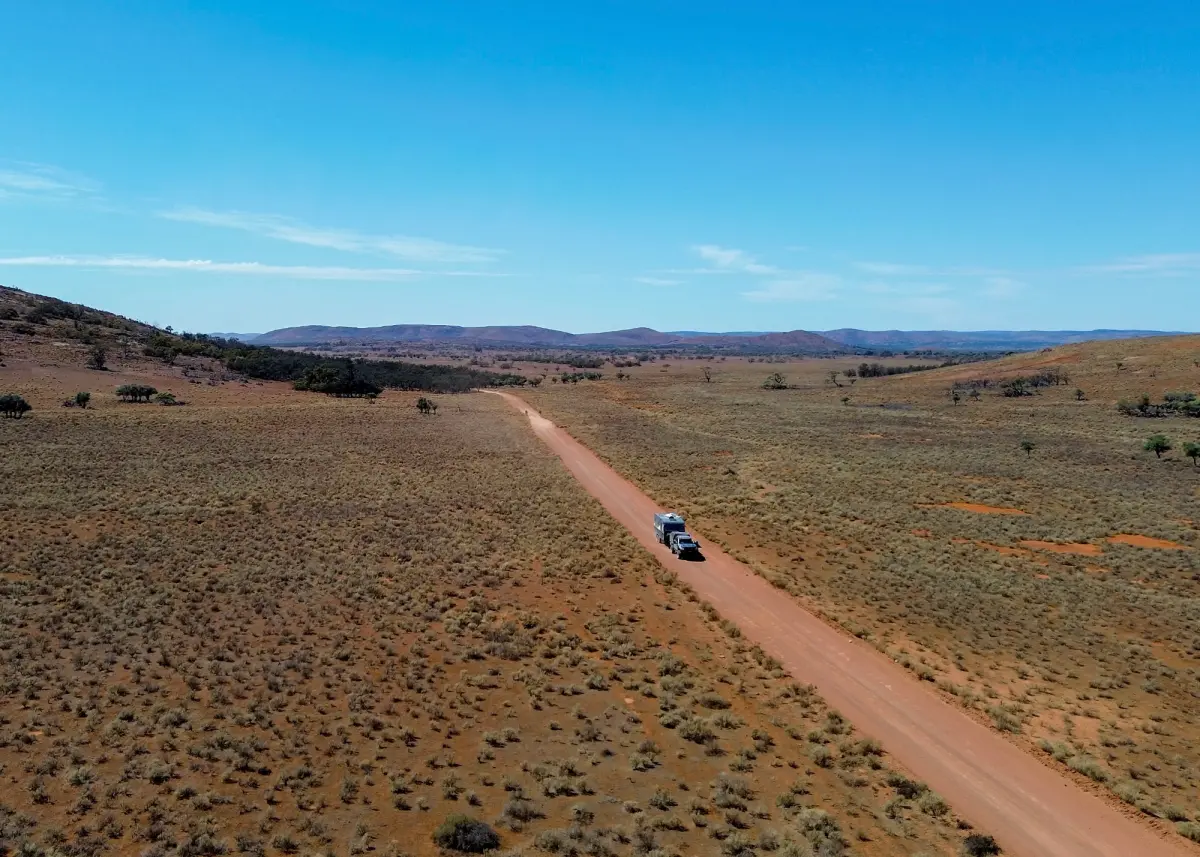 4x4 towing a caravan through an arid landscape