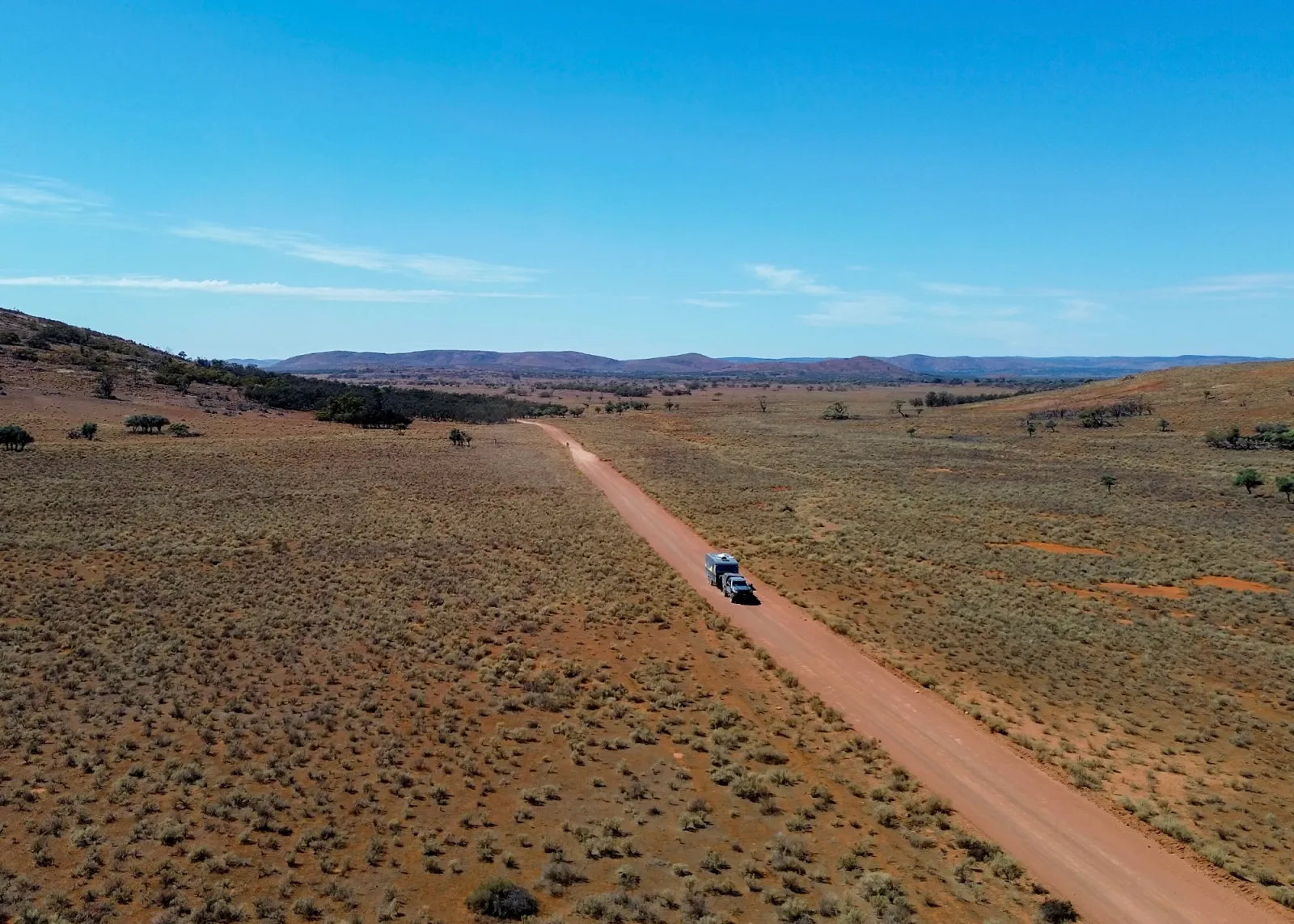 4x4 towing a caravan through an arid landscape