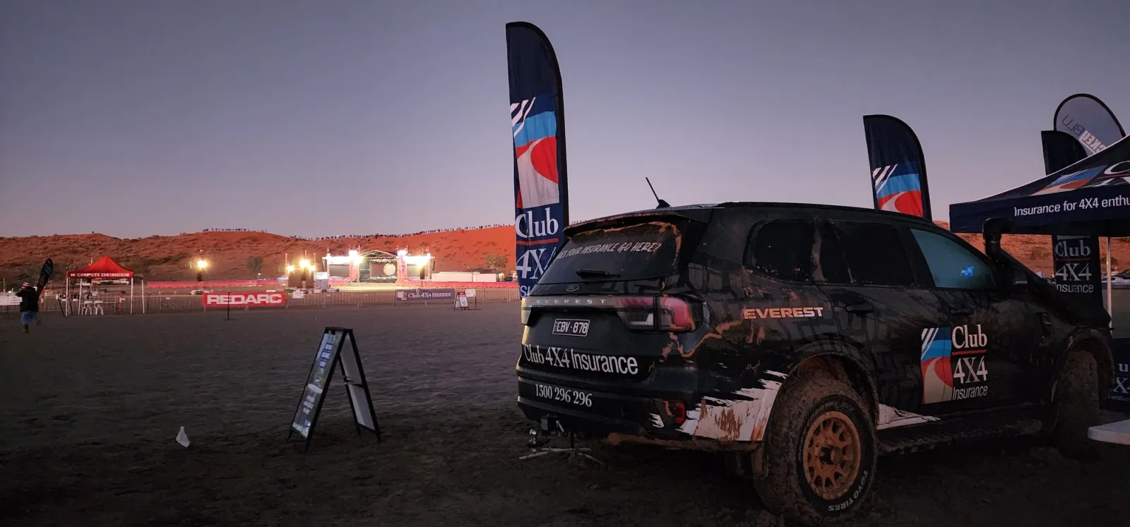 club 4x4 branded ford everest with flags in a desert at sunset