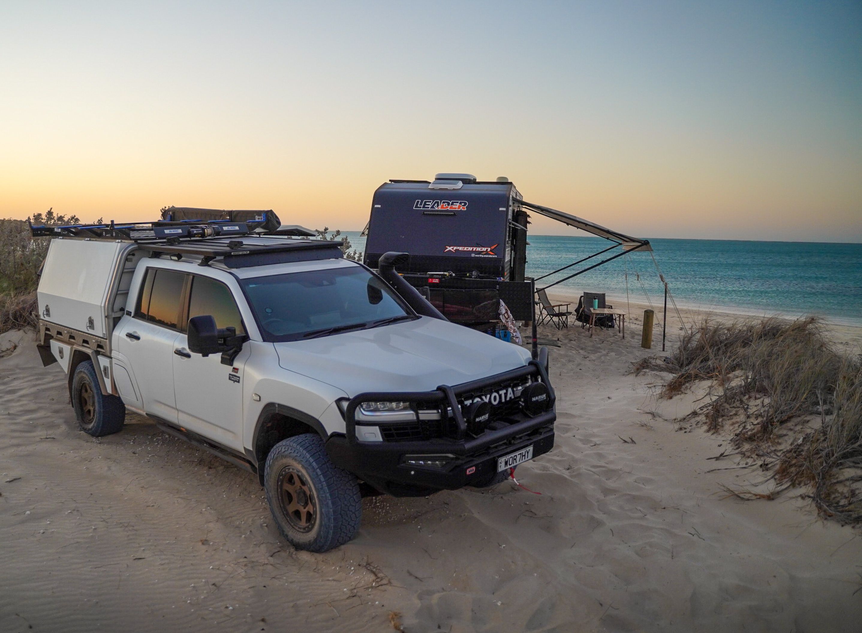 A 4WD Toyota and a caravan camped on a beach