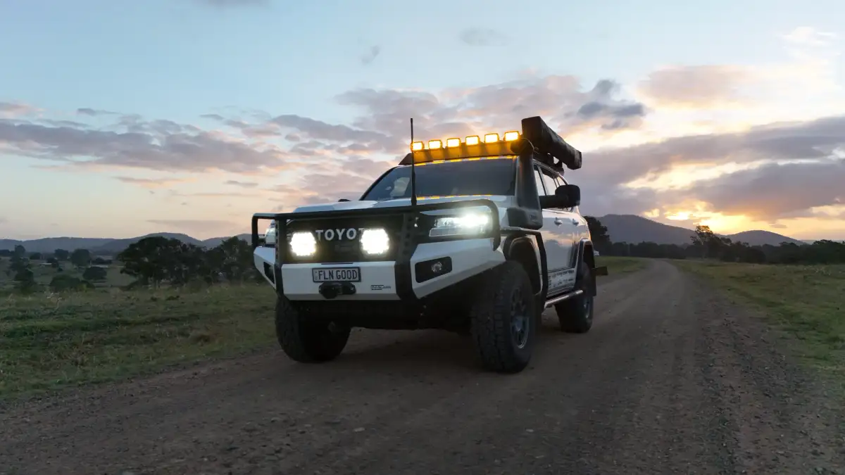 4wd at dusk with lights on in outback