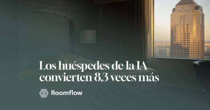 Habitación de hotel en penumbra con la ciudad al fondo, tras la ventana.