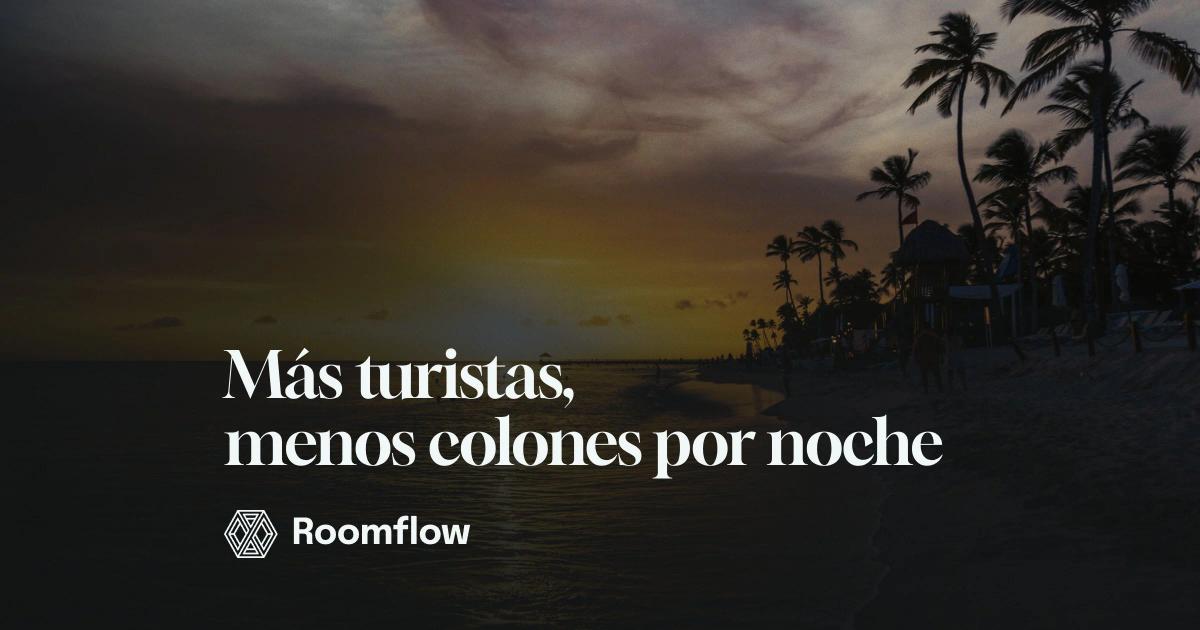 Atardecer en una playa tropical, con palmeras en silueta y el mar en calma.