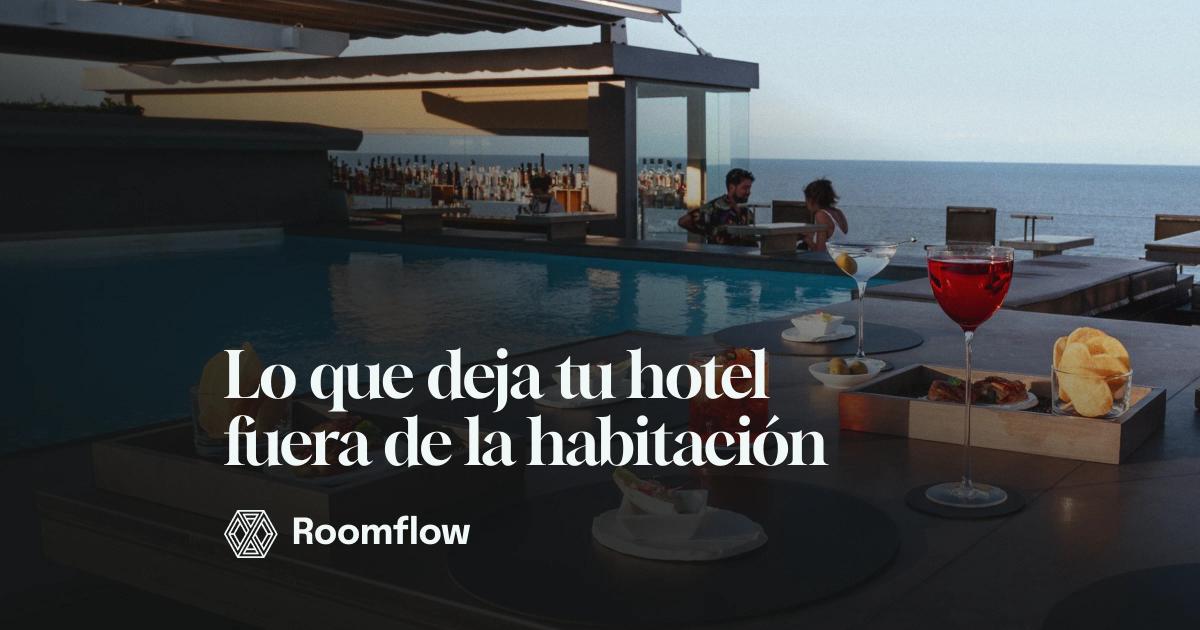 Mesa con aperitivos y bebidas junto a la piscina de un hotel frente al mar.