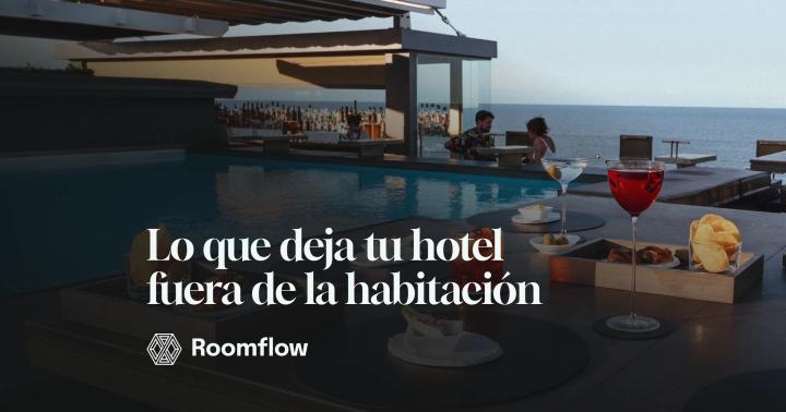 Mesa con aperitivos y bebidas junto a la piscina de un hotel frente al mar.