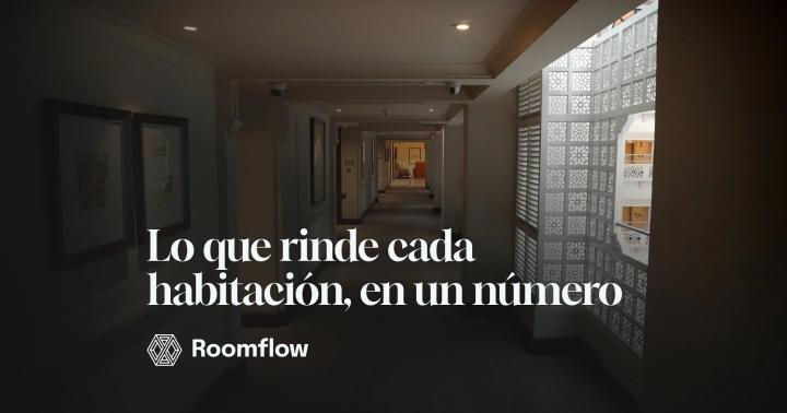 Pasillo de hotel con luz cálida, cuadros en la pared y puertas de habitaciones al fondo.
