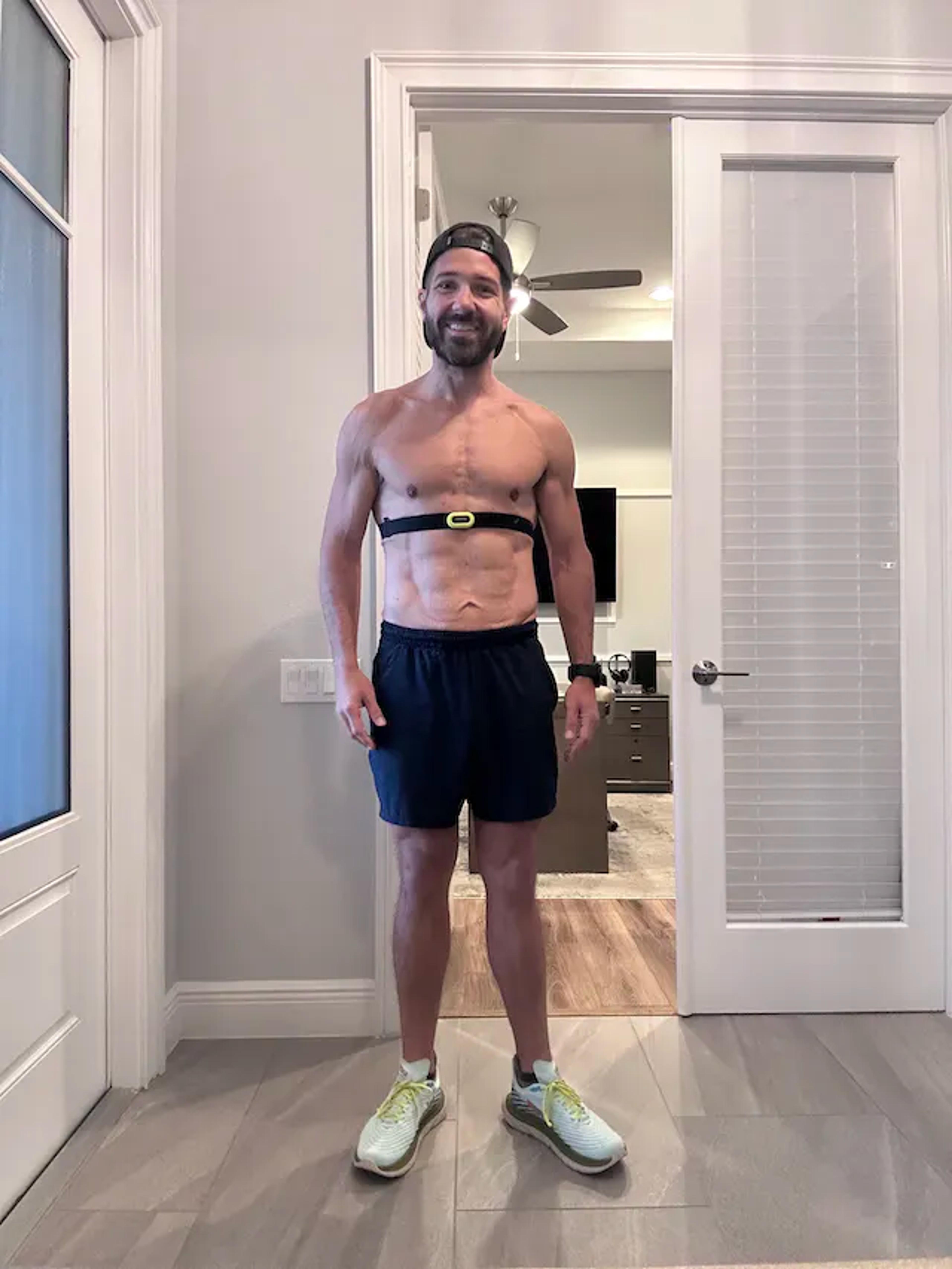 Pat Cahill standing shirtless in his foyer ready to go on a run at 10% body fat