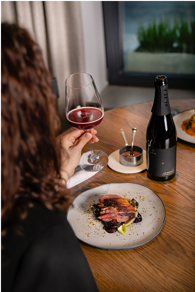 Donna di spalle beve vino in un ristorante elegante