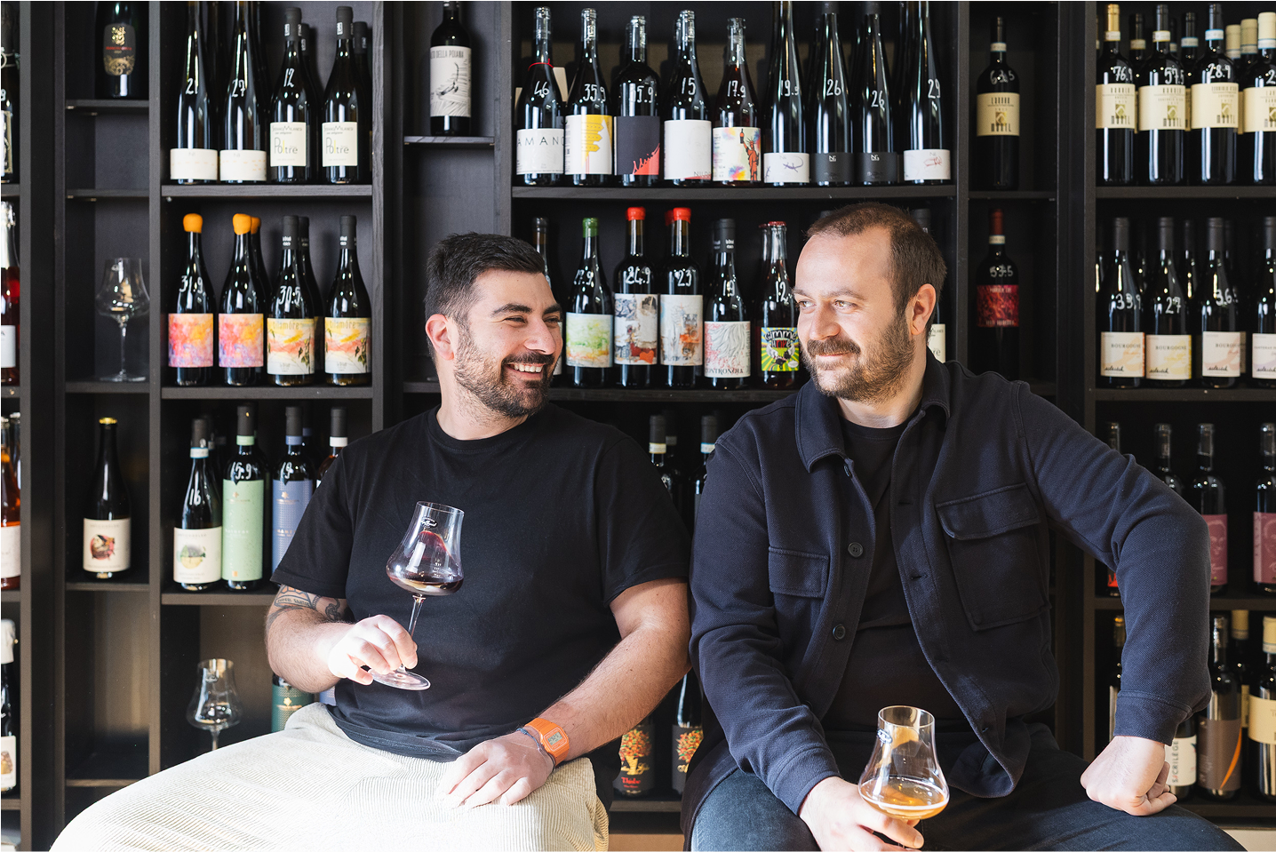 I co-fondatori di Lo-Haus, Matteo e Alberto, brindano insieme in un'enoteca