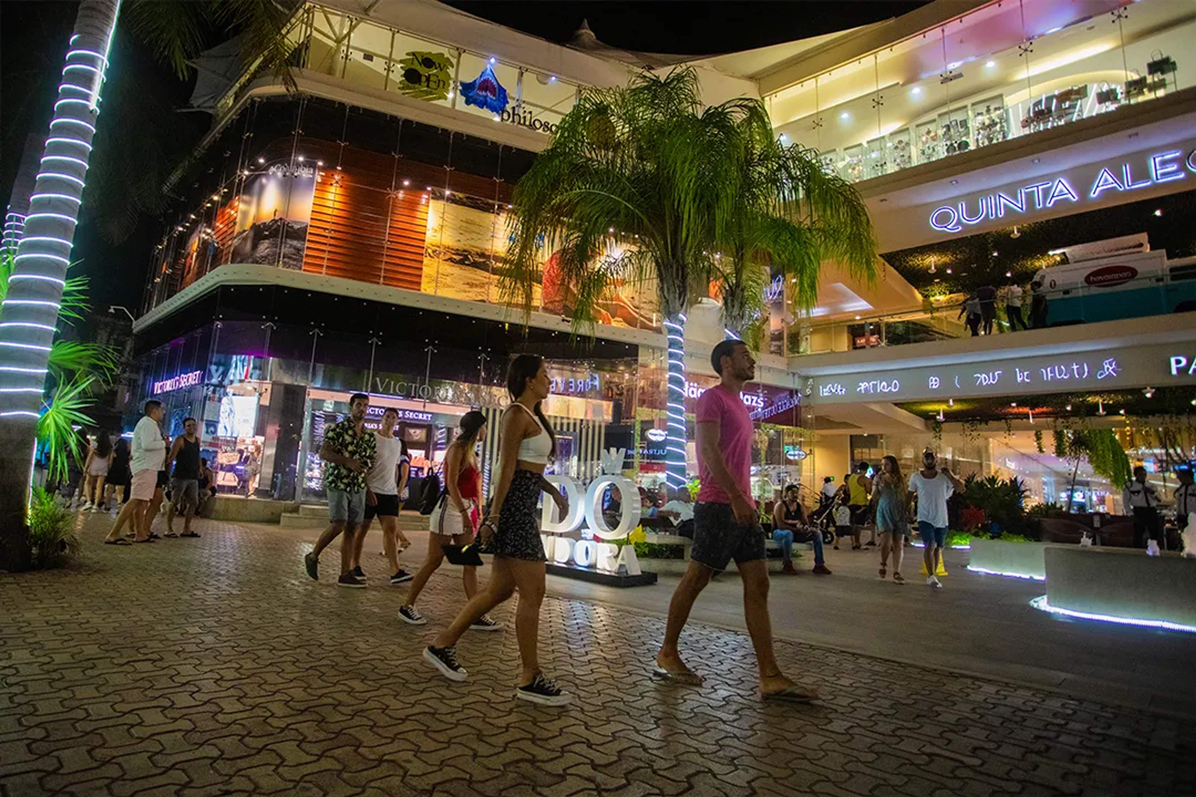 Vida nocturna y compras en Quinta Alegría, Playa del Carmen, con gente paseando.