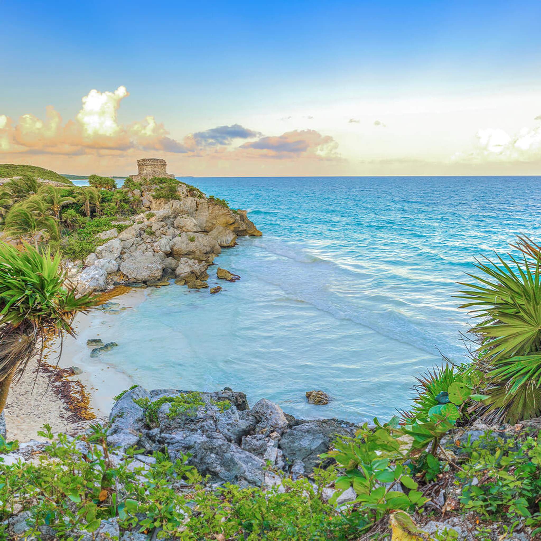 Una vista impresionante de las ruinas de Tulum en un acantilado rocoso con vistas a las aguas turquesas del mar Caribe en la Riviera Maya.