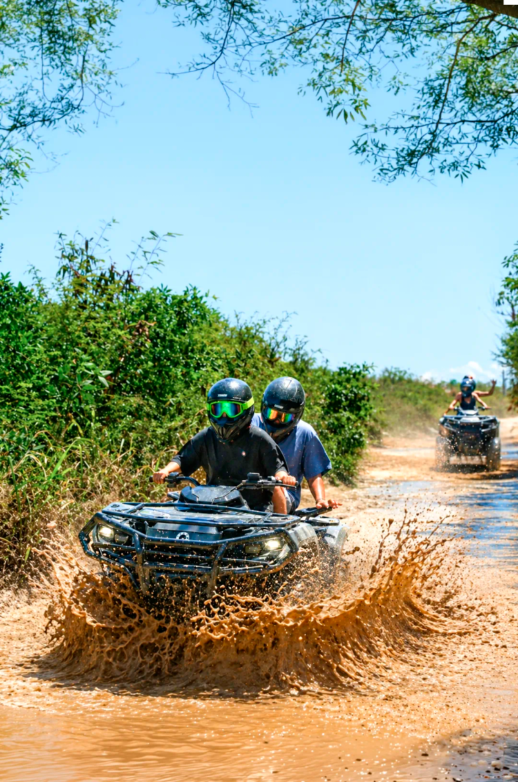 Viajeros de Cancún en una expedición en cuatrimoto a través de la selva de Akumal en la Riviera Maya.