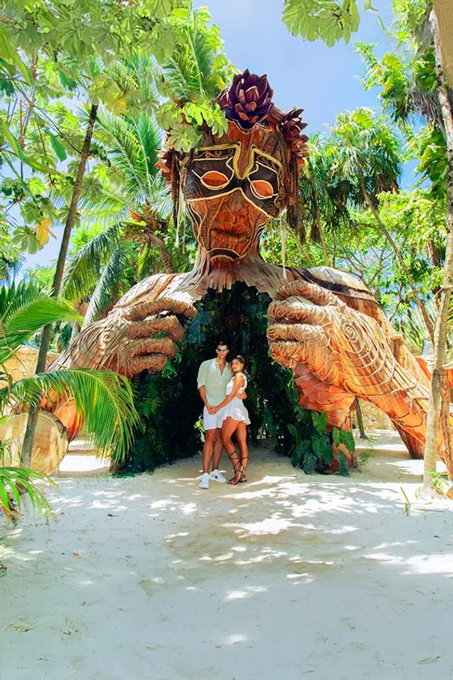 Couple posing in front of the "Ven a la Luz" sculpture in Tulum