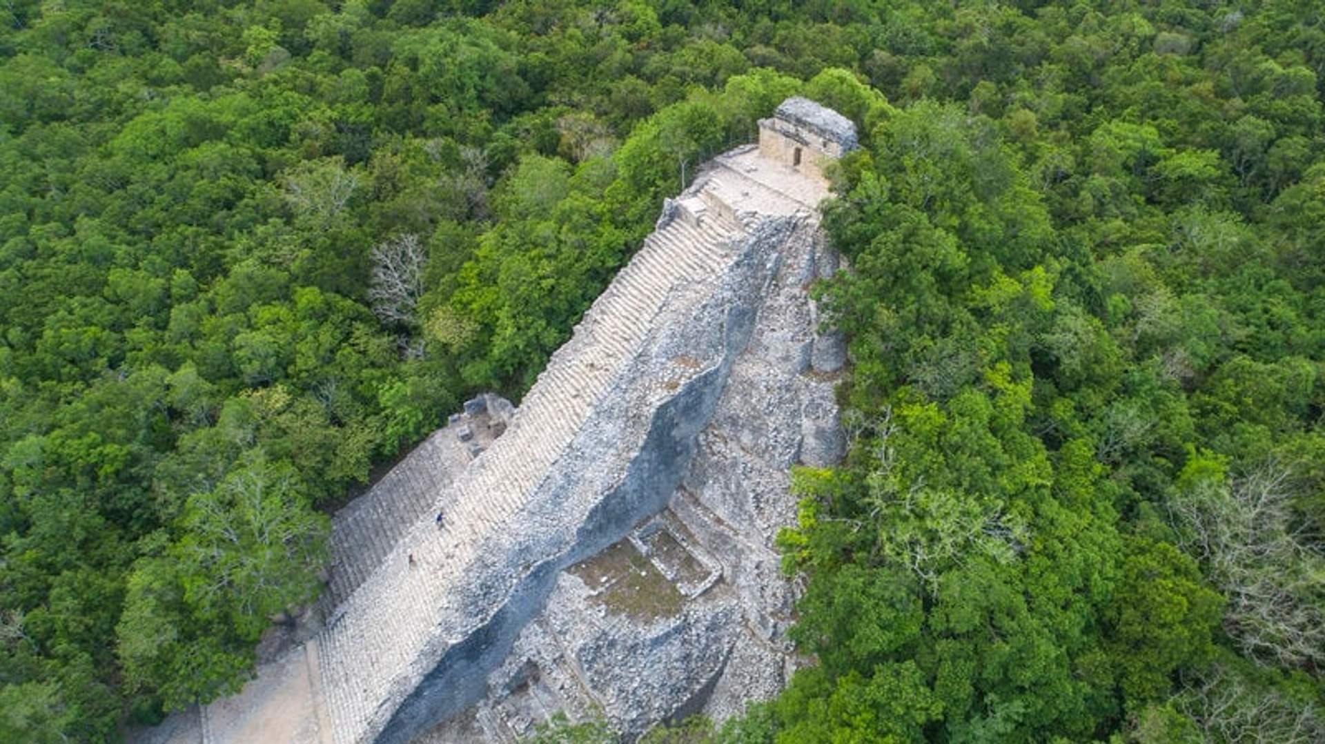 Aerial view of the Nohoch Mul pyramid in the Coba ruins, surrounded by dense jungle.