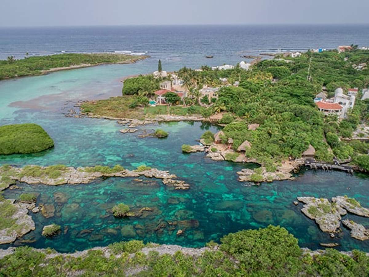 Aerial view of Yal Ku Lagoon, showcasing its clear turquoise waters and lush greenery