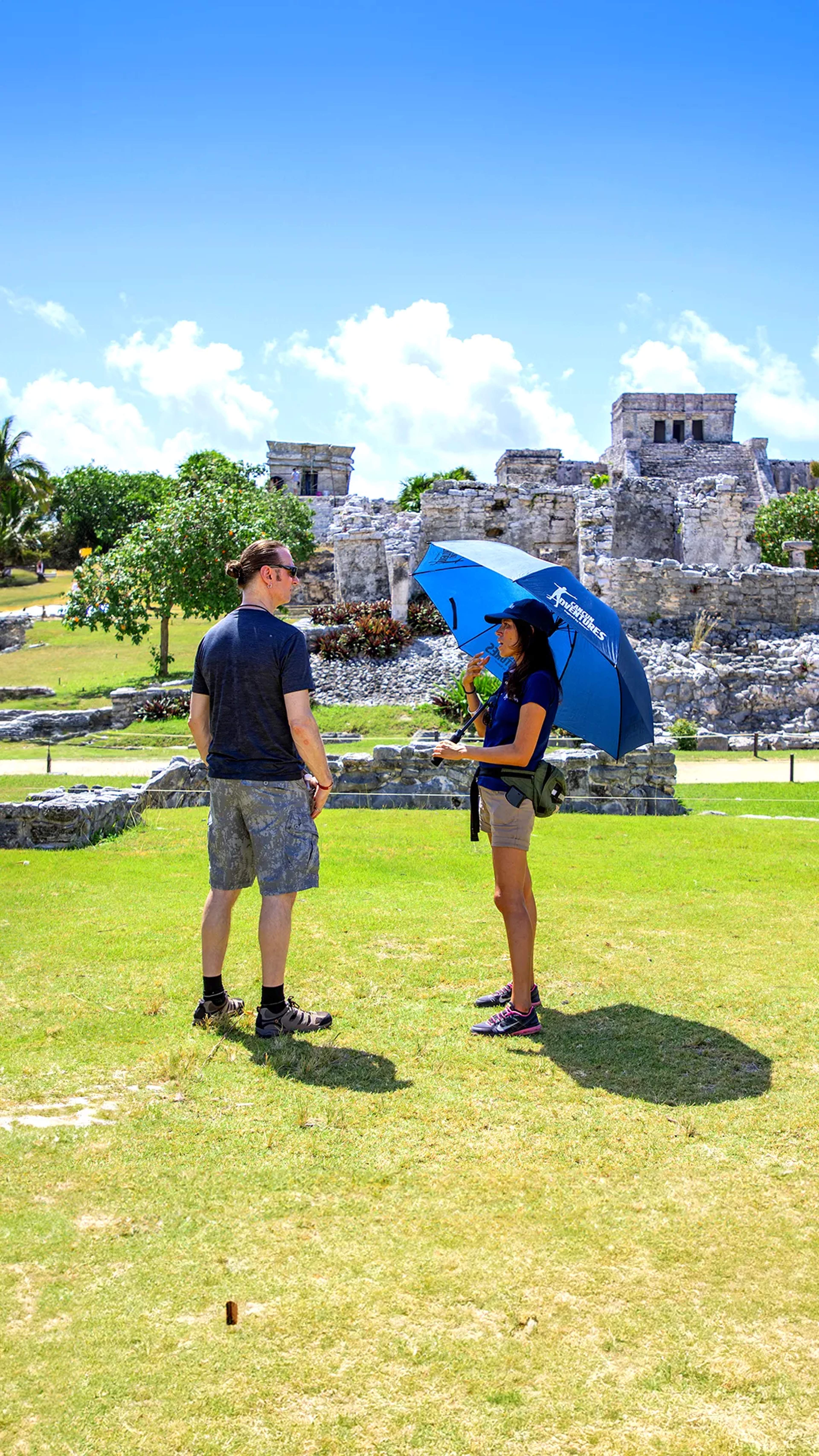 Tulum ruins, frontal view of an ancient Mayan pyramid surrounded by dense green jungle.