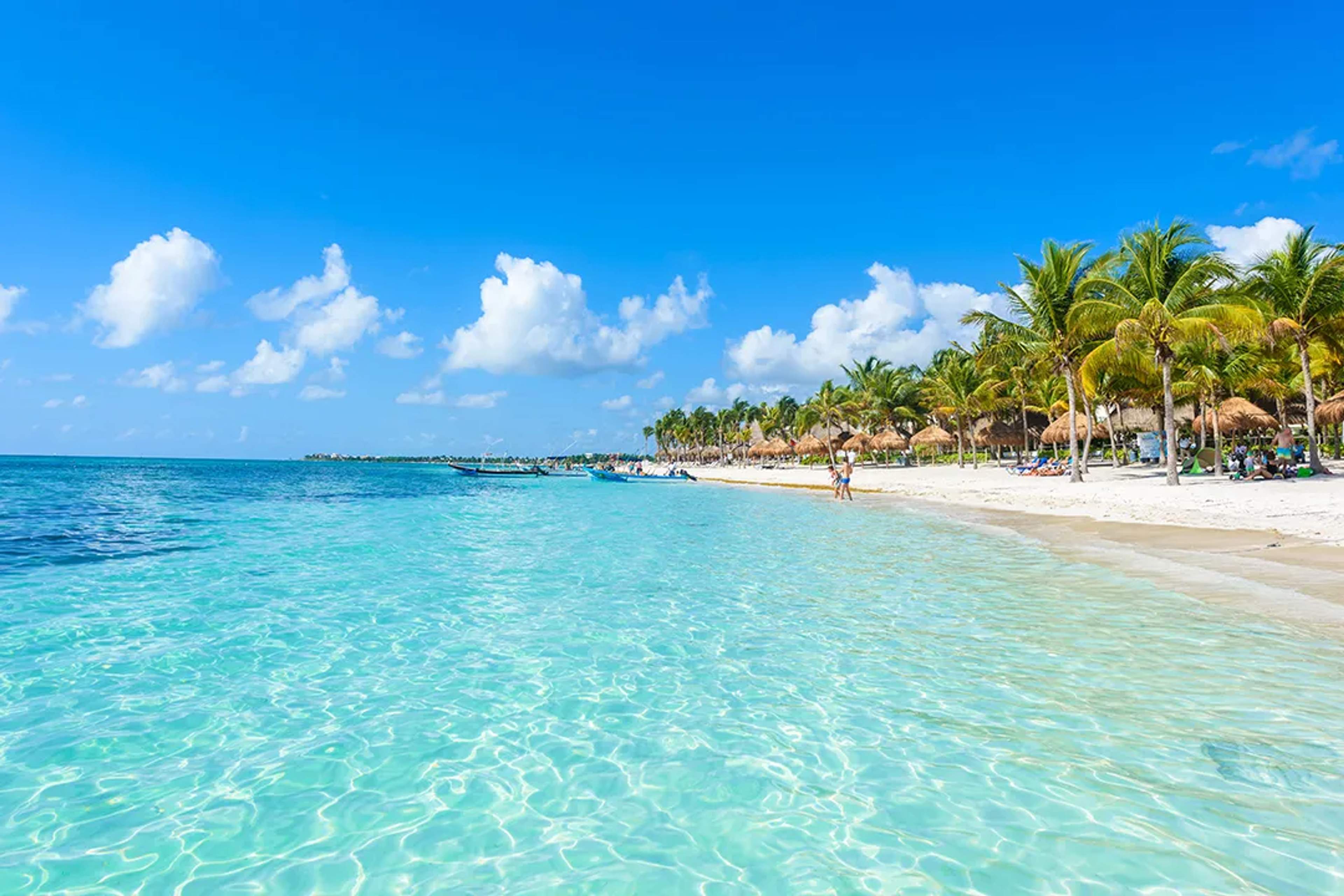 Crystal-clear Caribbean waters and white sand beach in Riviera Maya on a tropical catamaran tour