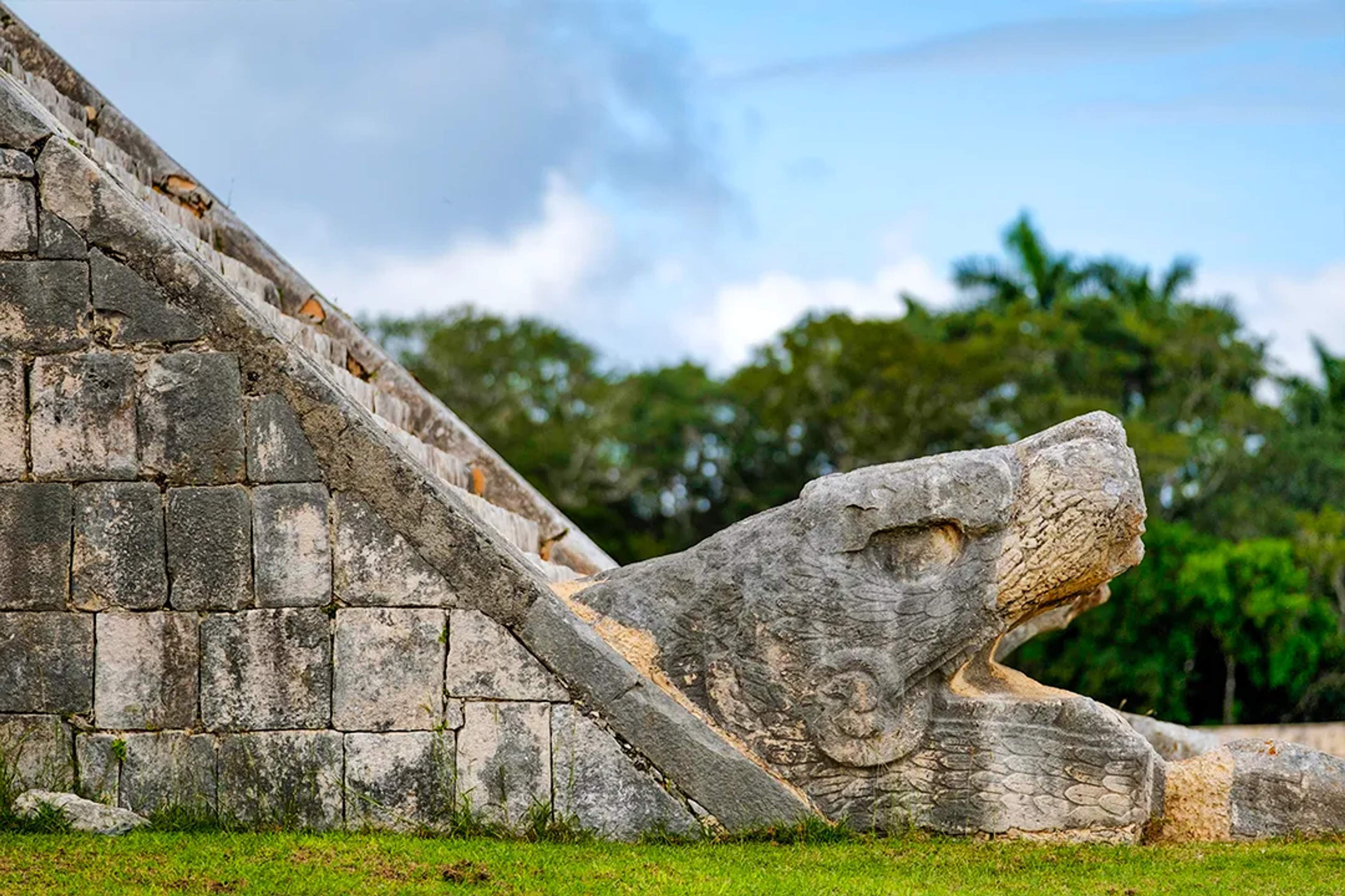 Cabeza de serpiente en pirámide de Kukulkán en Chichén Itzá, detalle de ruinas mayas en Yucatán en tour guiado