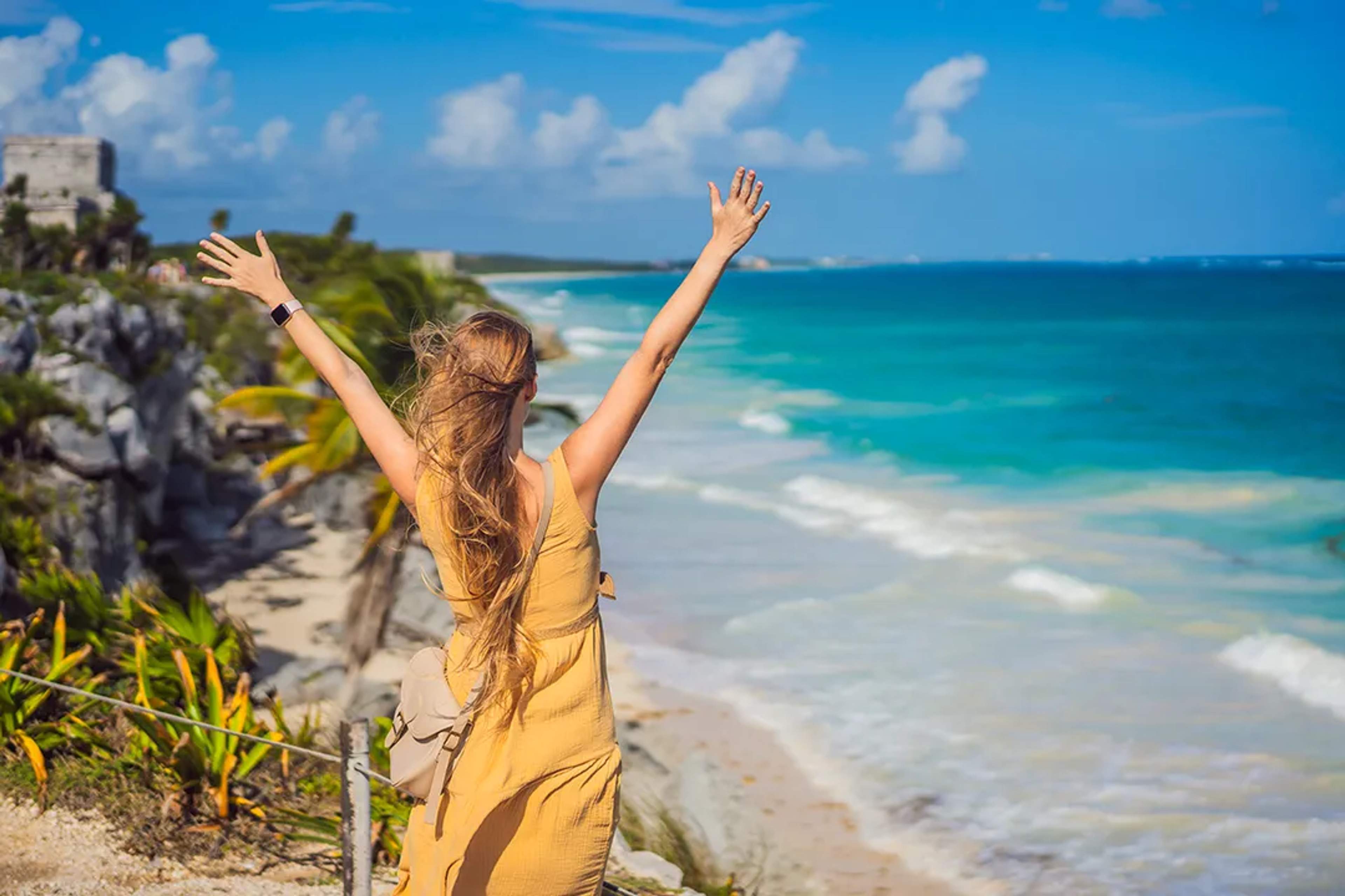 Viajera disfrutando vistas del mar en Tulum durante tour cultural en Riviera Maya, México