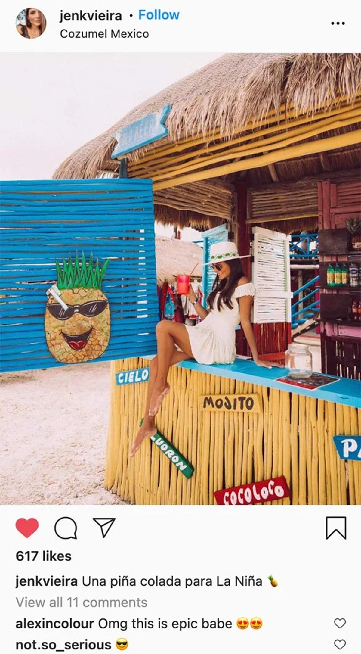 A woman enjoying a drink at a colorful beach bar in Cozumel, with a pineapple decoration and signs.
