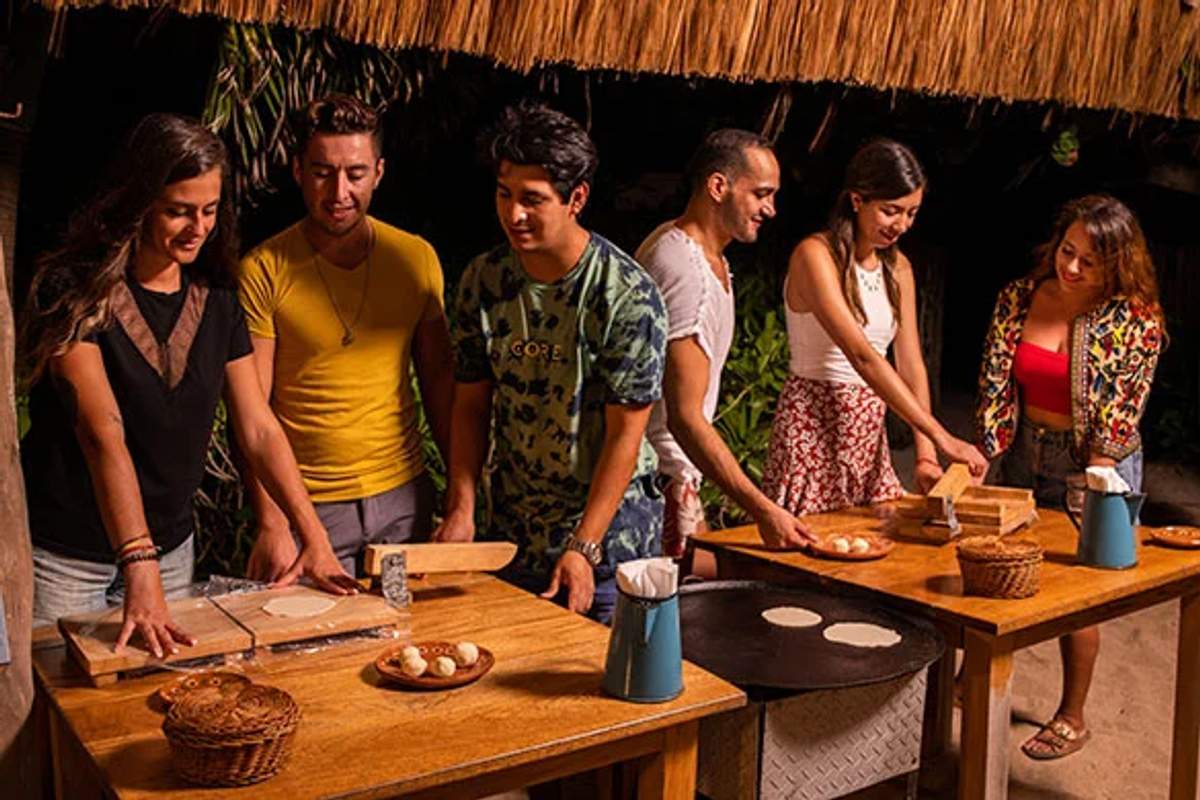 Pequeño grupo aprendiendo a hacer tortillas durante una clase de cocina en Cancún.