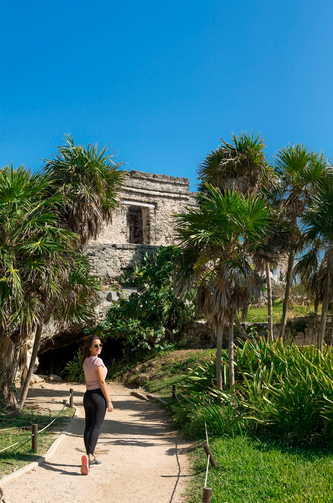 Woman walking the Tulum archaeological site