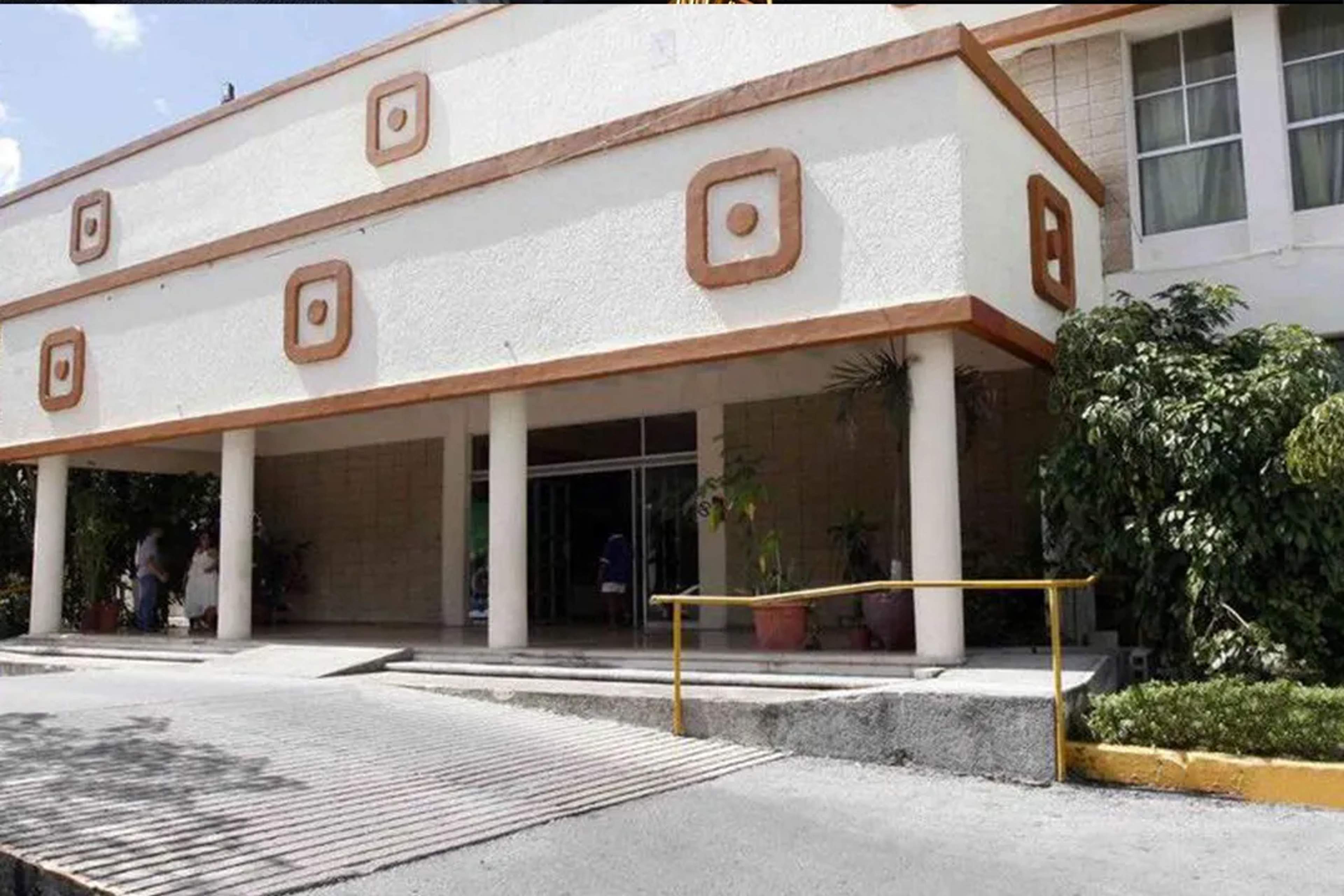 Entrada de un centro cultural con columnas, decoraciones y rampa de acceso.