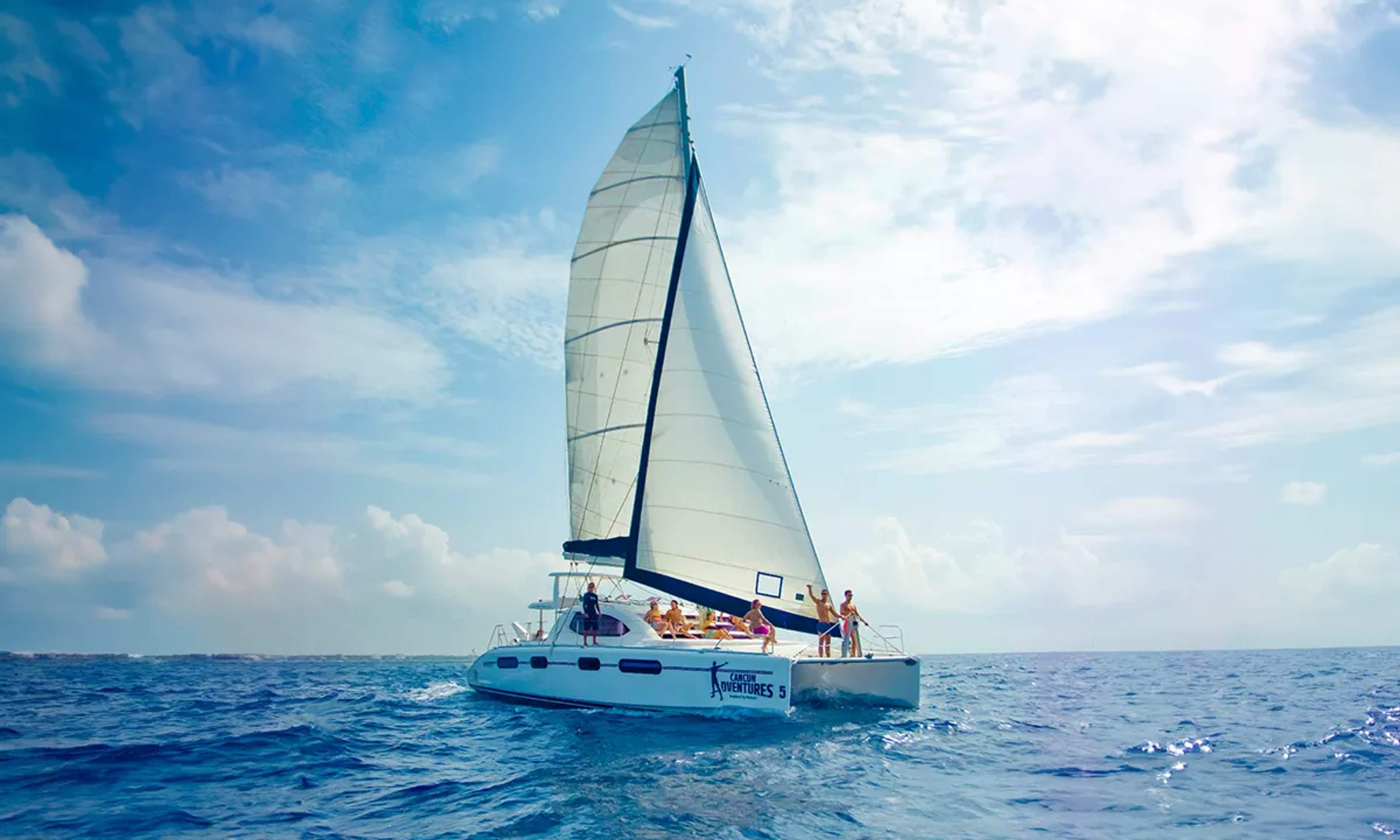 Catamaran sailing on the crystal-clear Caribbean waters under a clear sky, perfect for enjoying the sea and breeze.