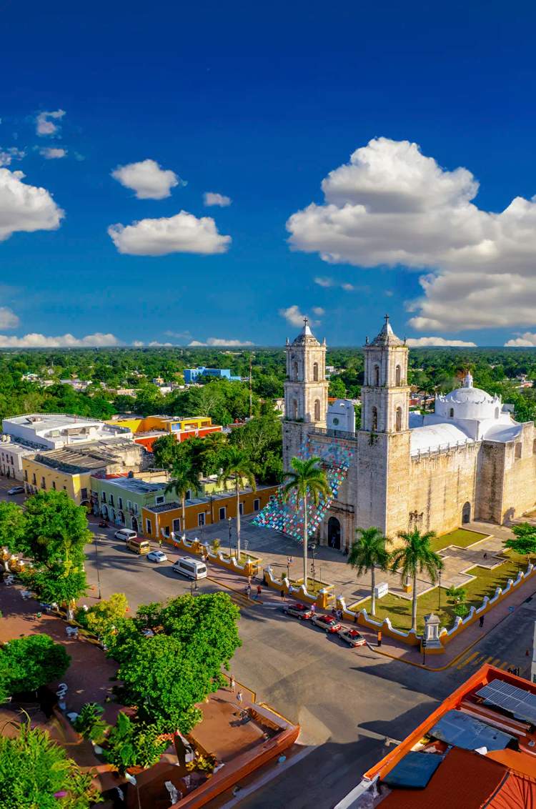 Aerial view of San Gervasio Cathedral in Valladolid, surrounded by colorful colonial buildings.
