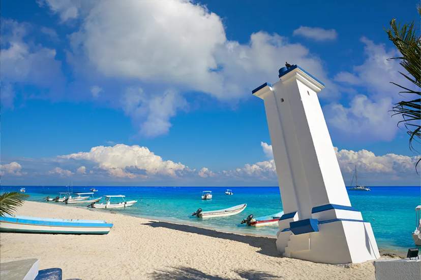 Puerto Morelos lighthouse by the Caribbean Sea near Cancun Adventures, with boats, white sand and turquoise waters
