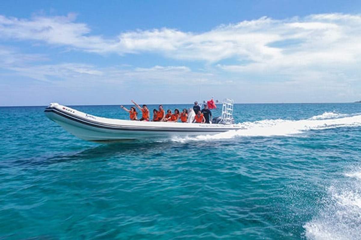 Pequeño grupo disfrutando de un tour en lancha rápida sobre aguas turquesas en Cozumel.