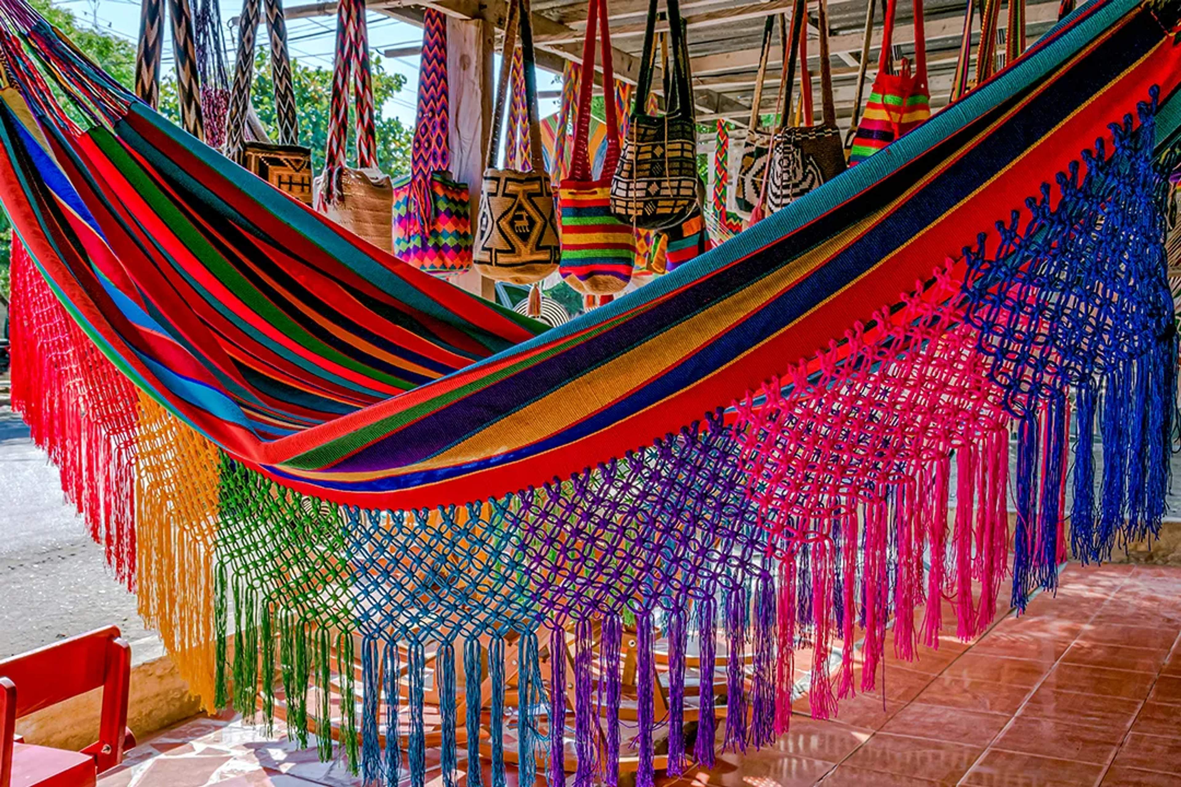Hamaca colorida y bolsas tejidas en exhibición en un mercado tradicional mexicano.