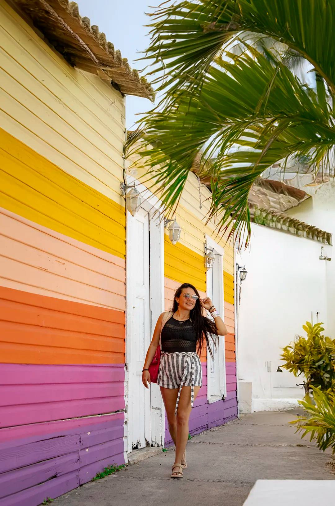 Woman strolling Isla Mujeres colorful streets.
