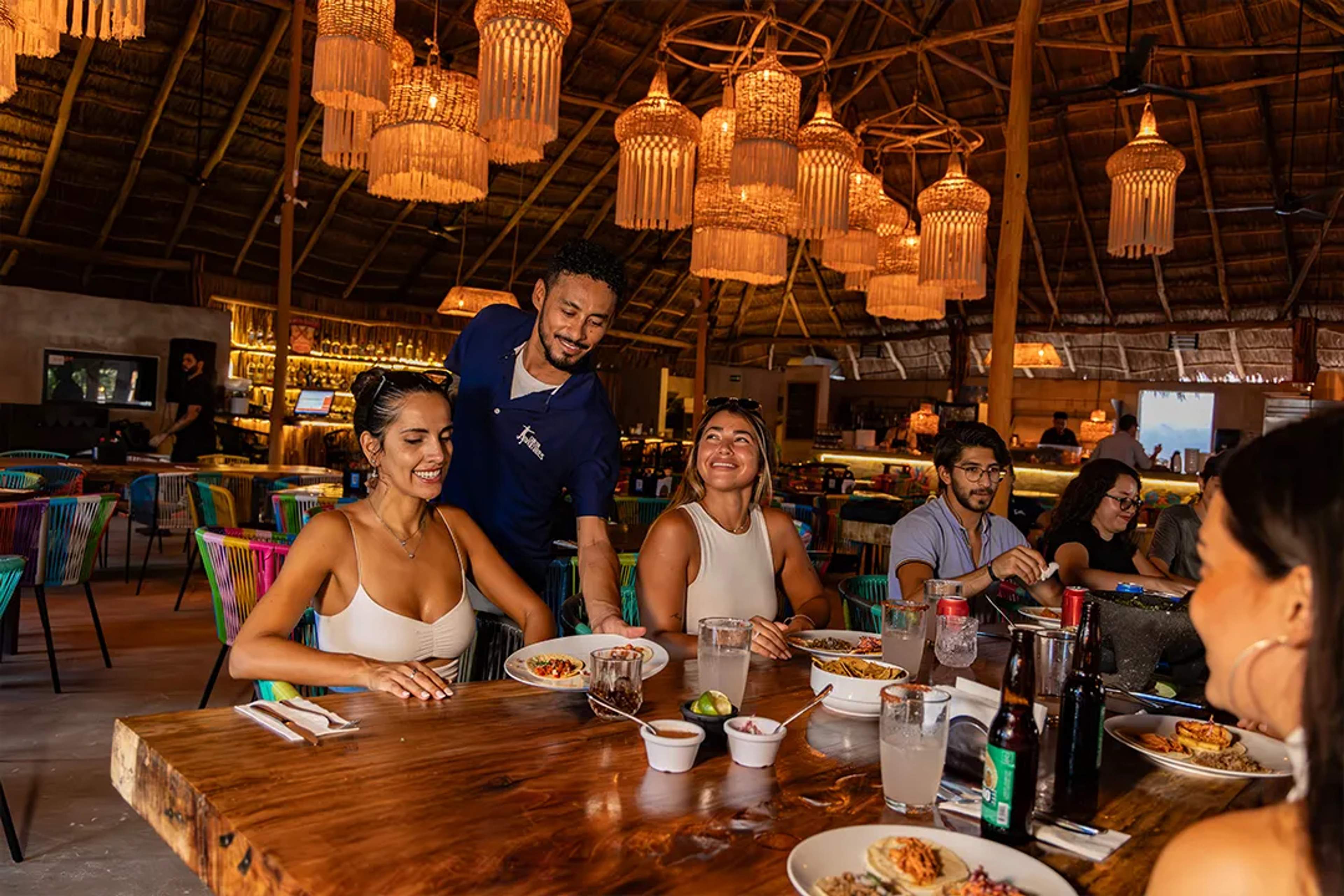 Visitantes disfrutando gastronomía mexicana auténtica en experiencia culinaria con Cancun Adventures en la Riviera Maya