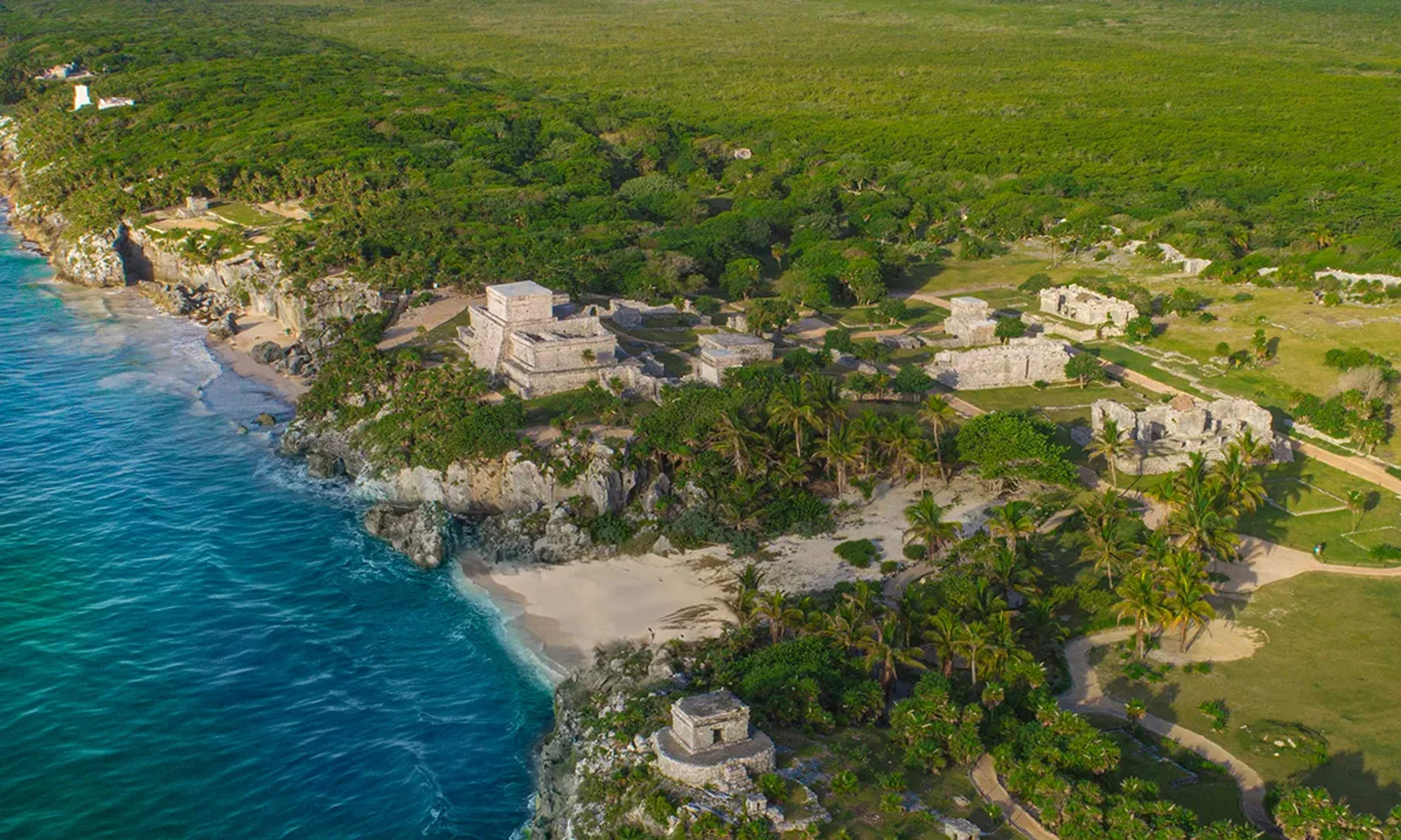 Vista aérea de las ruinas mayas de Tulum sobre acantilados junto al Mar Caribe, combinando historia, naturaleza y vistas impresionantes.