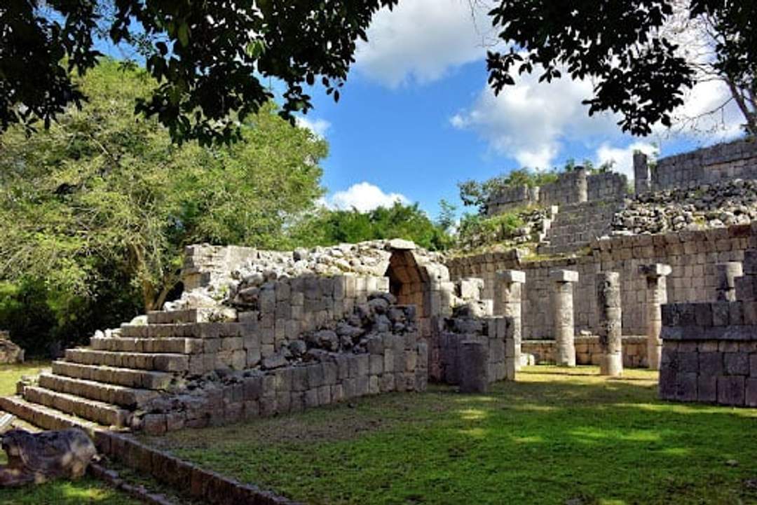 The Temple of the Wall Panels at Chichen Itza, featuring intricate carvings of battles, animals, and plants on its north and south walls.