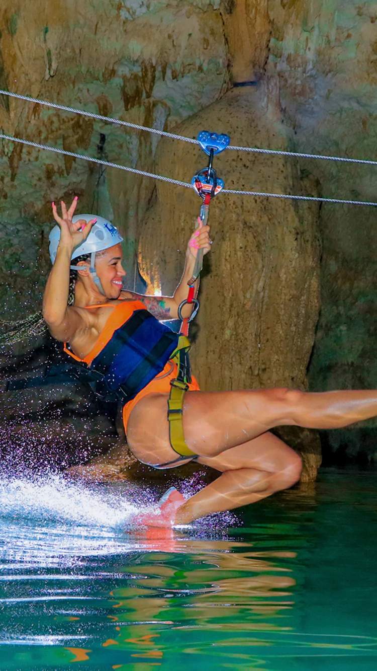 Cenote zipline adventure in Cancun with Cancun Adventures, splashing over crystal water