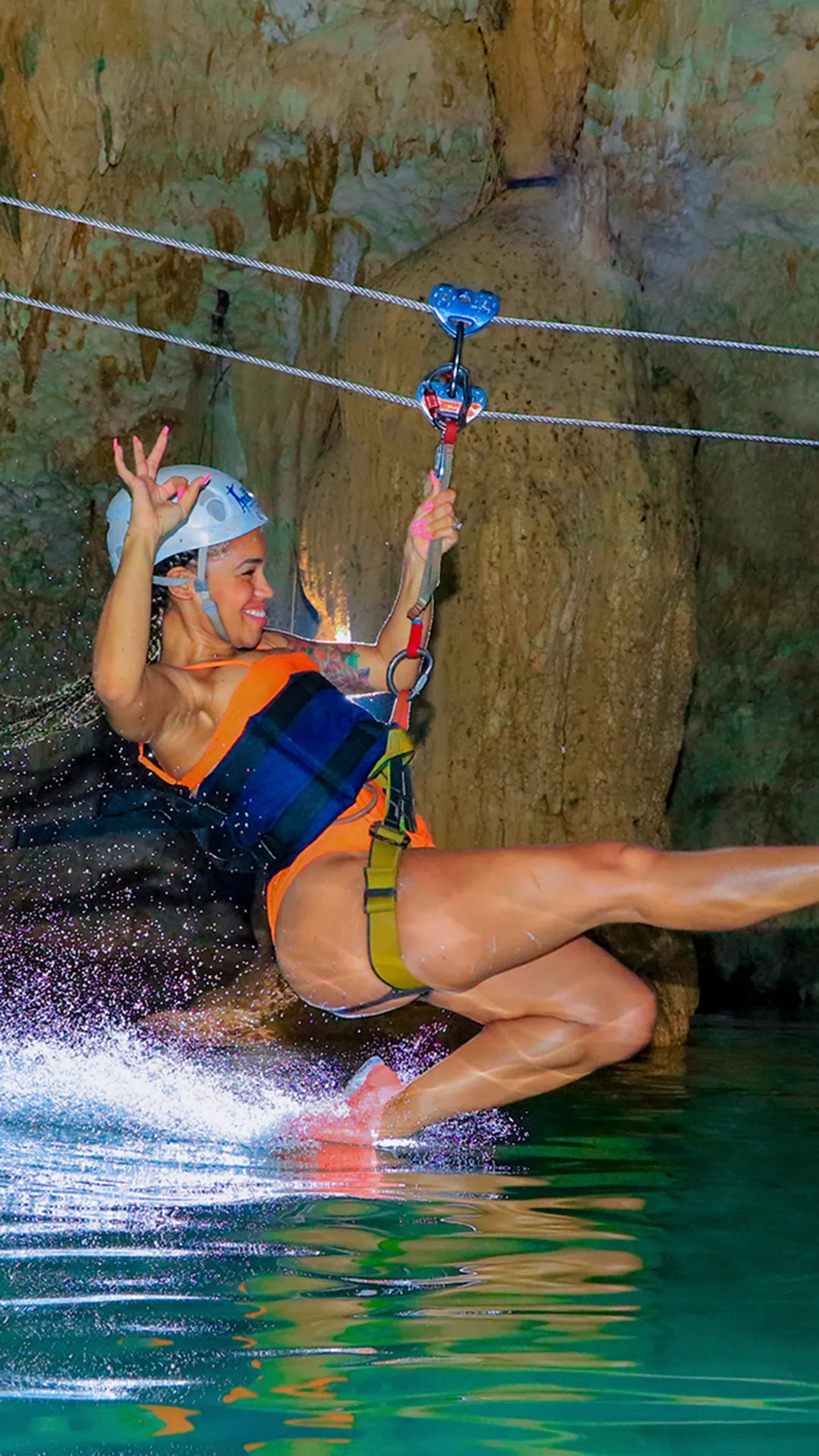 Aventura de tirolesa en cenote en Cancún con Cancun Adventures, deslizándose sobre agua cristalina