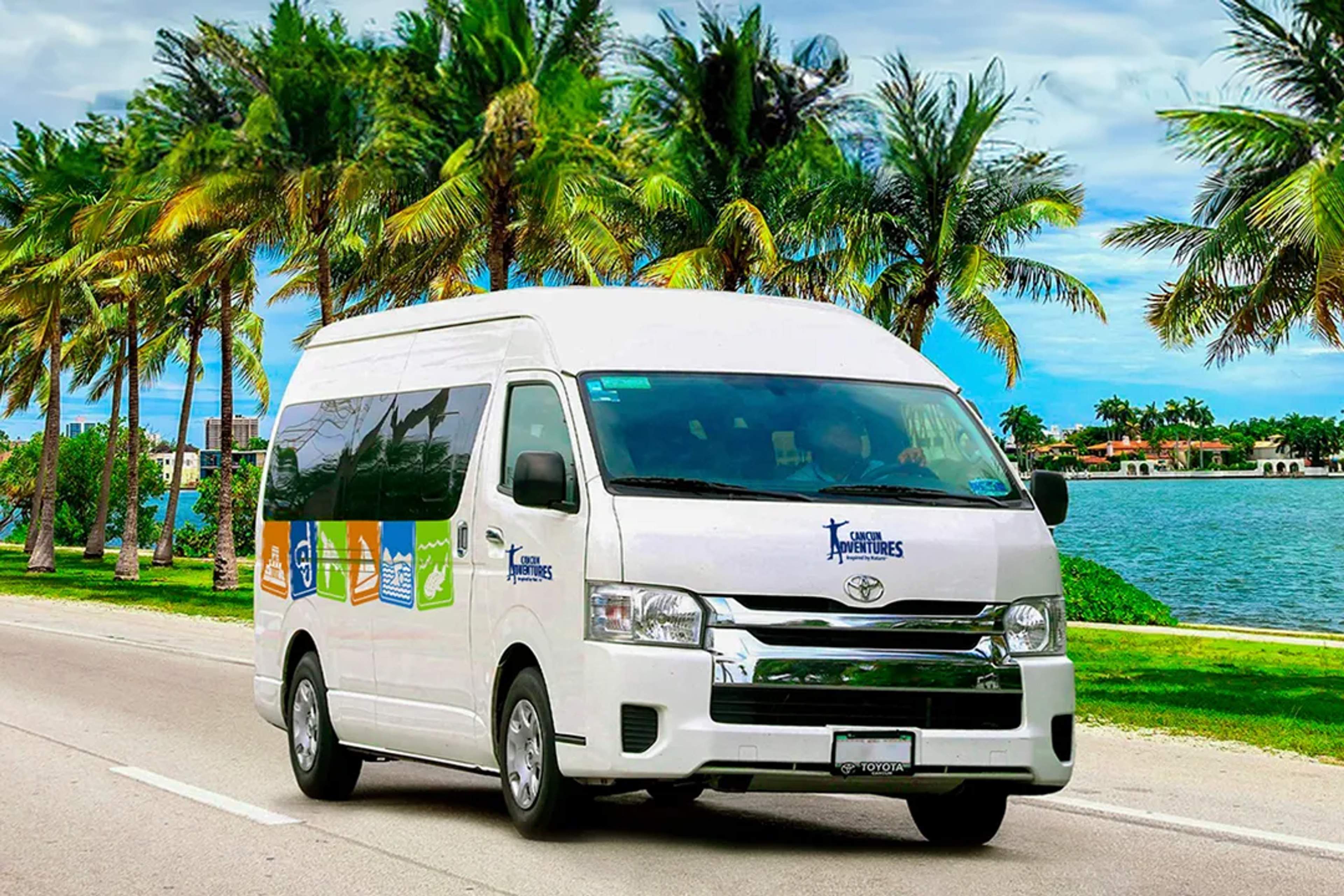 Cancun Adventures van driving by palm trees and water, perfect for tropical transportation.