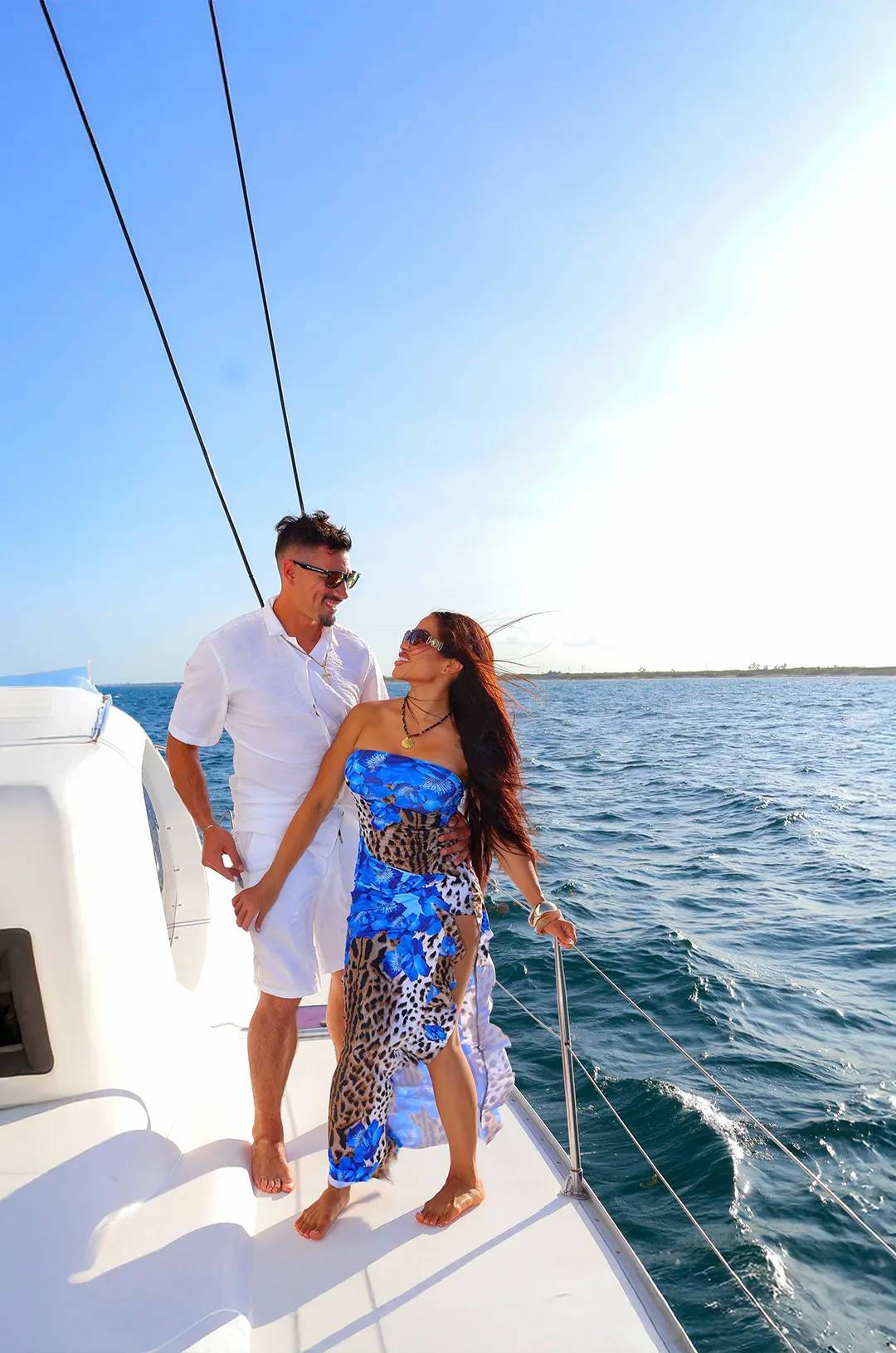 Couple on a catamaran deck sailing through Puerto Morelos