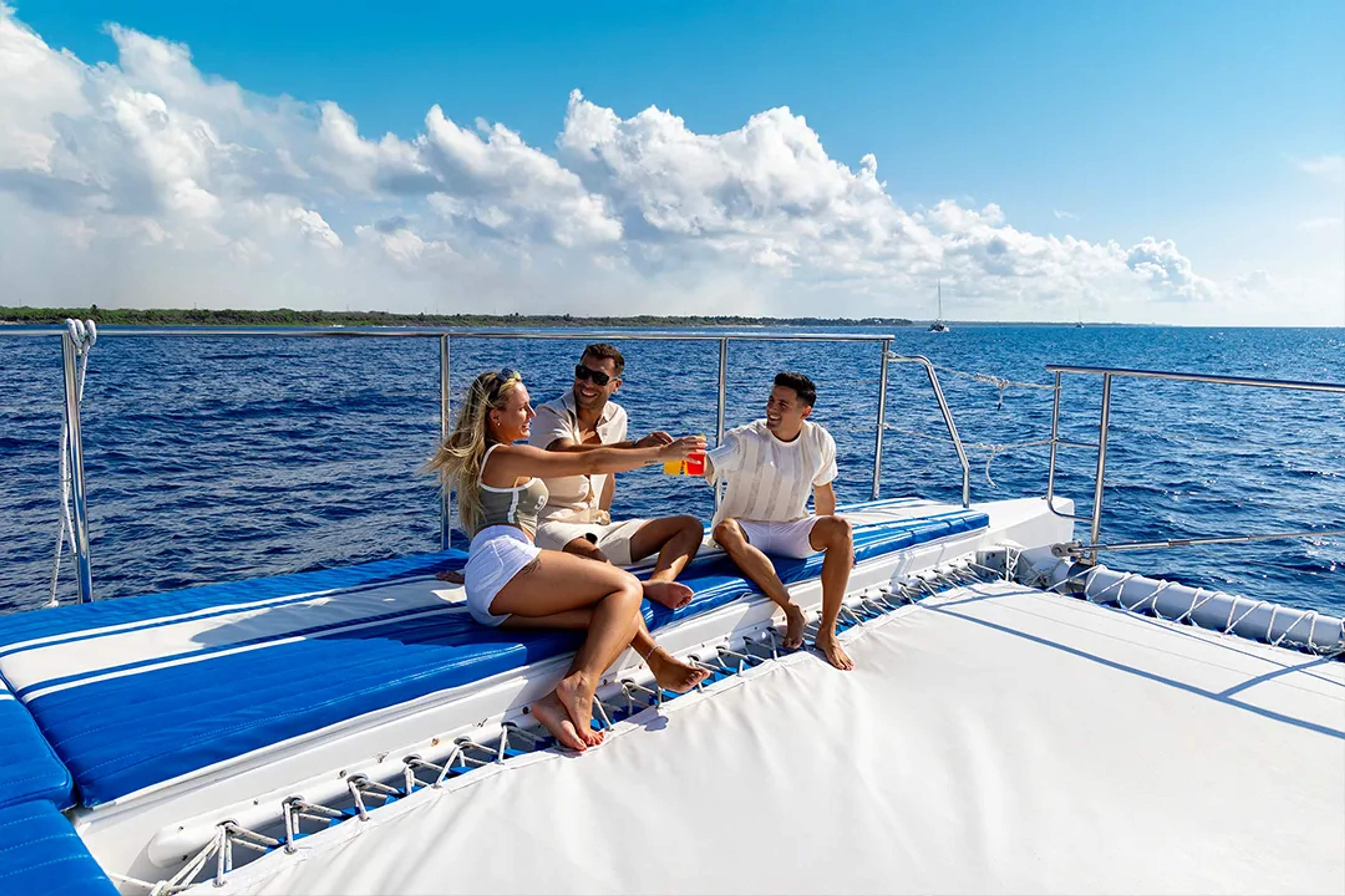 Friends relaxing on luxury catamaran, drinks in hand sailing Caribbean Sea on guided tour experience